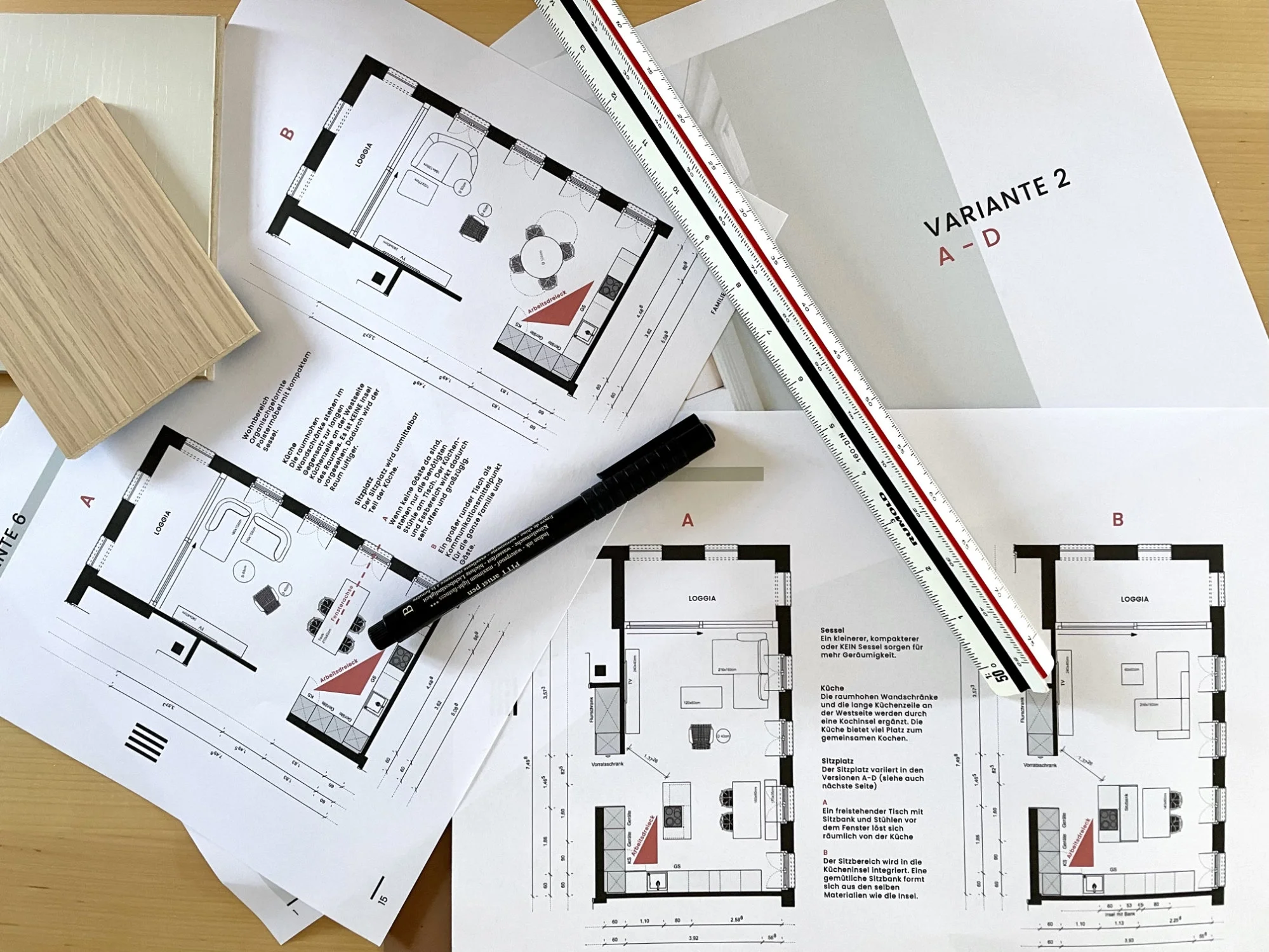 Zeichnungen von Wohnungsgrundrissen, Baupläne, Zeichenstifte, Holzmustern, einem Maßstab und Dokumenten auf einem Tisch.