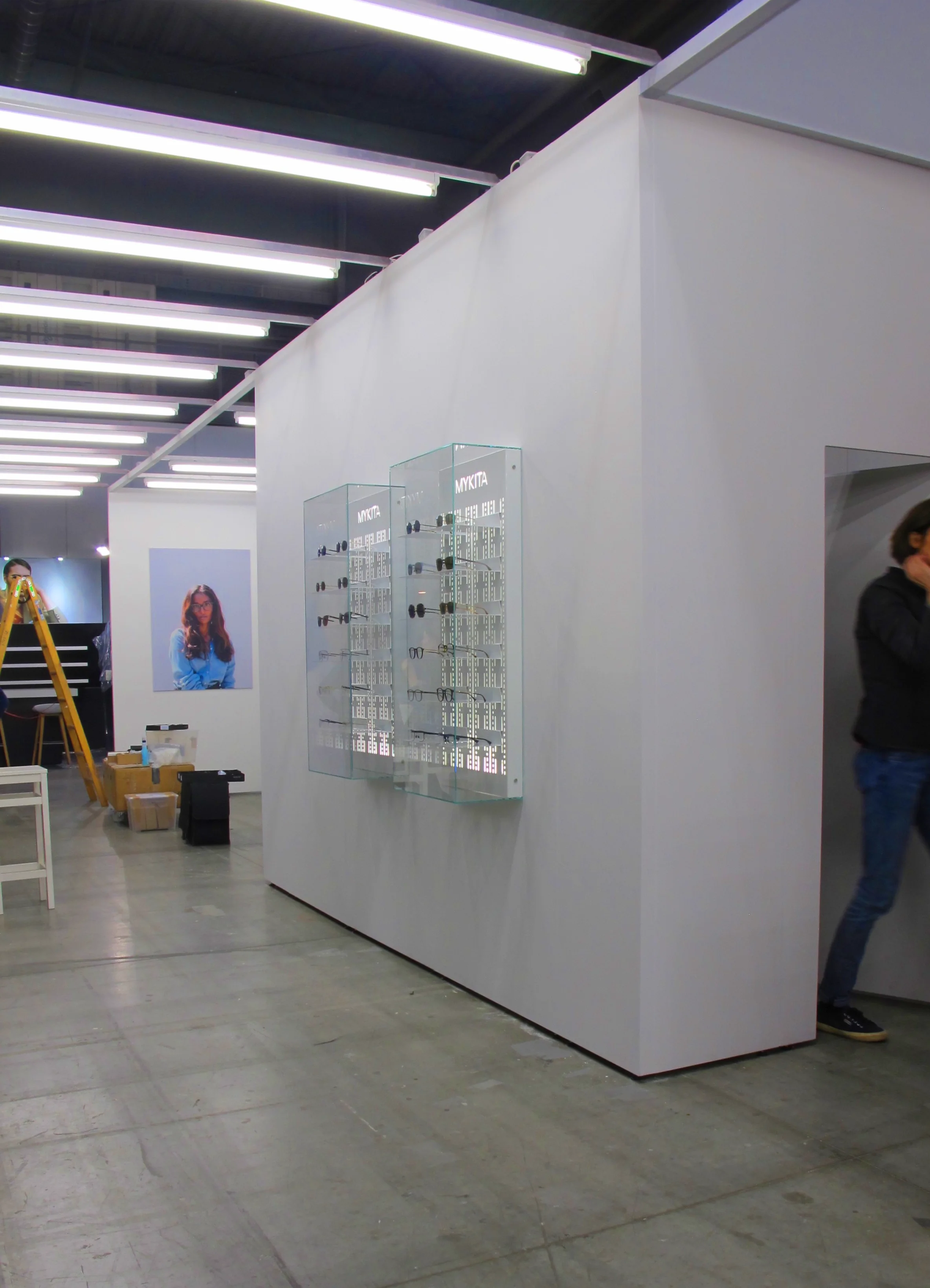 Der Mittelgang zwischen 2 separaten Messeständen des Unternehmens wird durch eine Reihung von Leuchtstoffröhren erhellt und betont und zieht den Messebesucher sofort an.