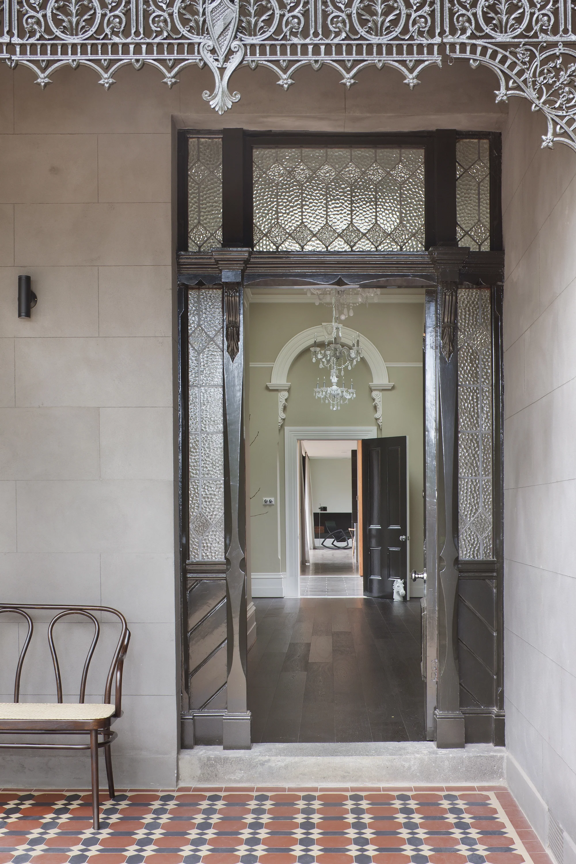 Sanierter Eingangsbereich eines denkmalgeschützten Hauses mit geöffneter Haustür und dem Blick in den großzügigen Flur.