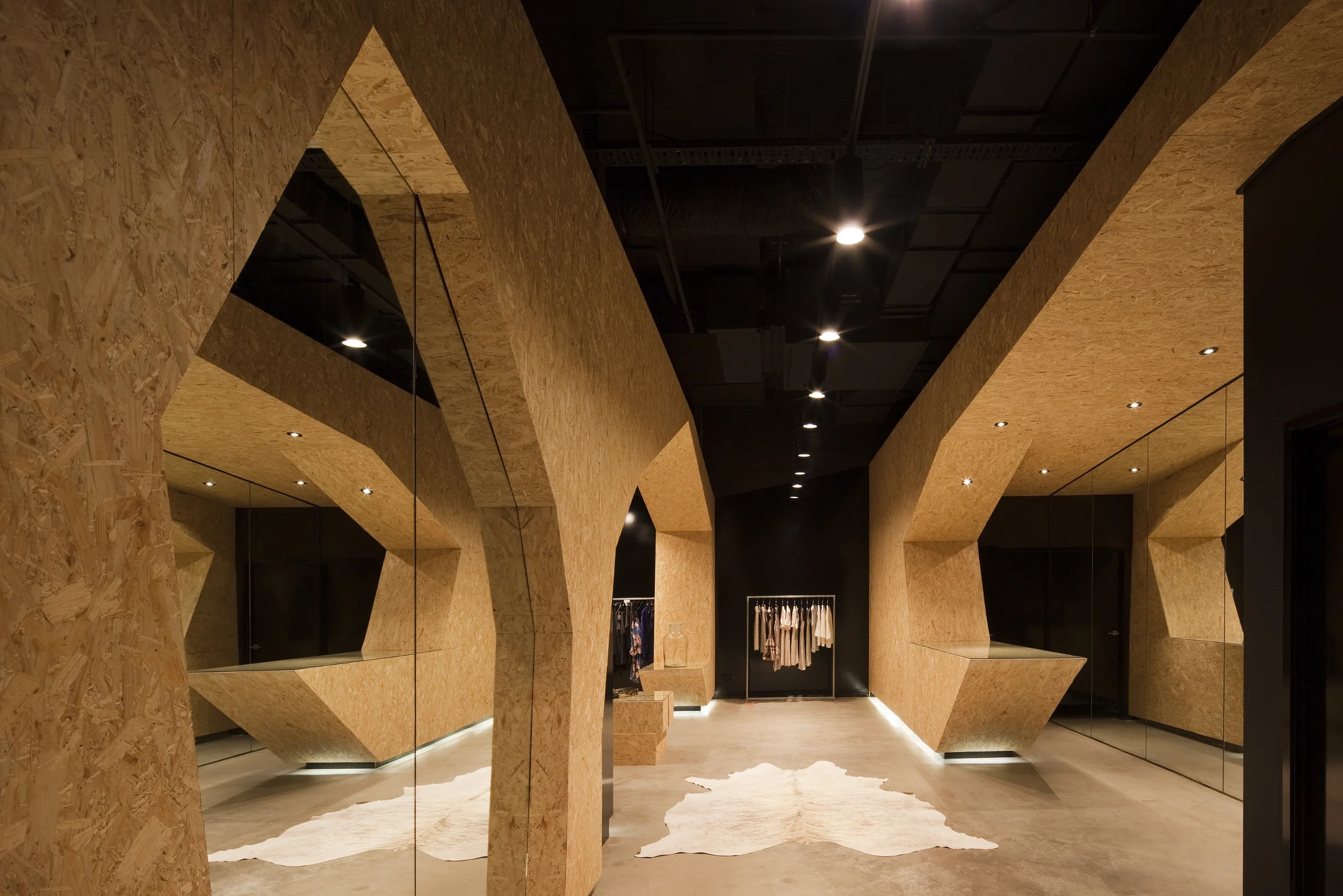 Die Umkleidekabinen mit schwarzen, schweren Vorhangstoffen fügen sich nahtlos in das skulpturale Gesamtkonzept ein.