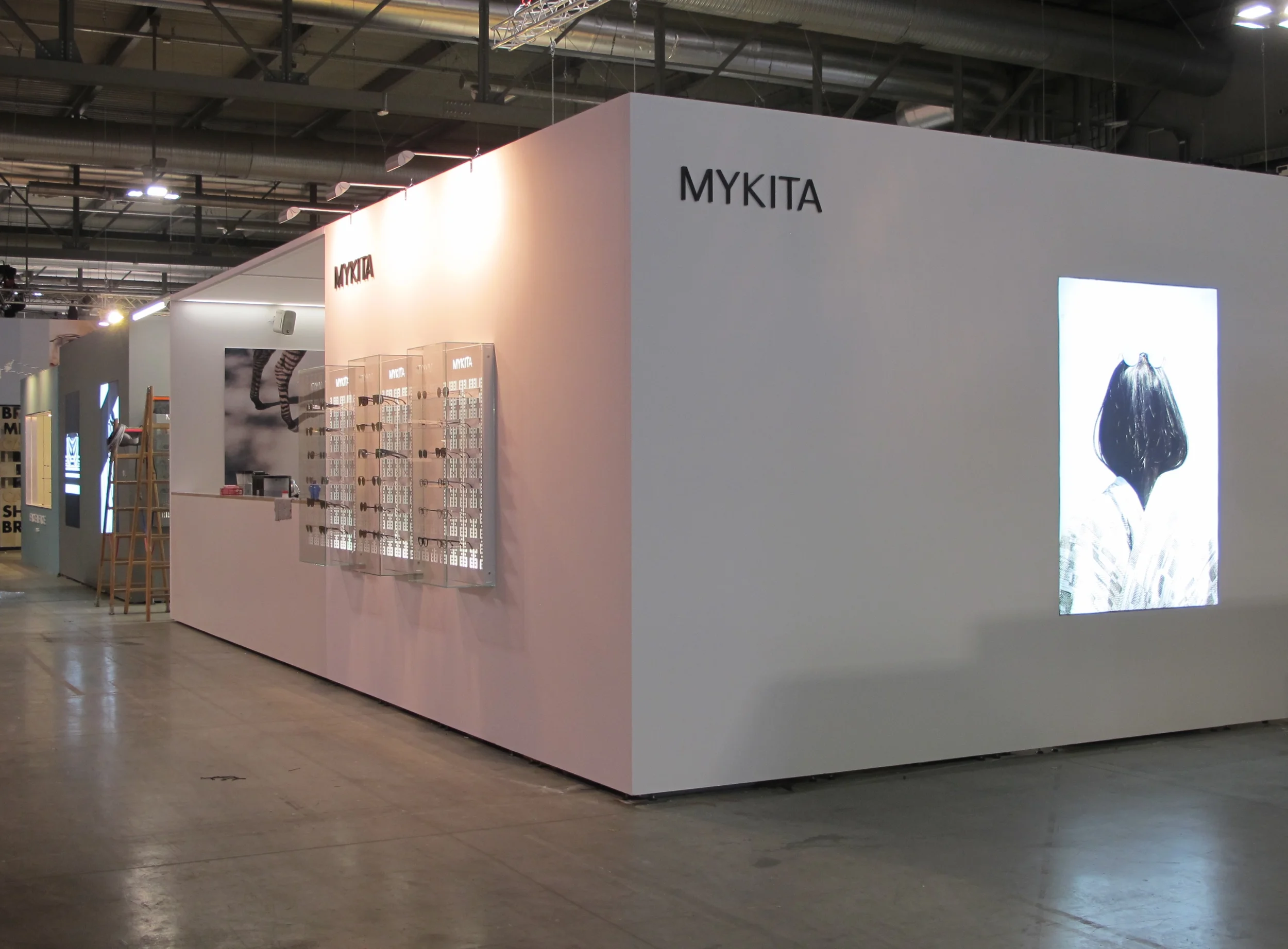 Dreidimensionale Logos des Unternehmens, hinterleuchtete Außenvitrinen mit ausgewählten Produkten und Kampagnenbilder spiegeln den minimalistischen und klaren Look der Marke wider.