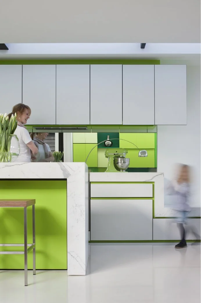 Supermoderne Küche in weiß und hellgrün, mit einer Kücheninsel und einer verspiegelten Rückwand.