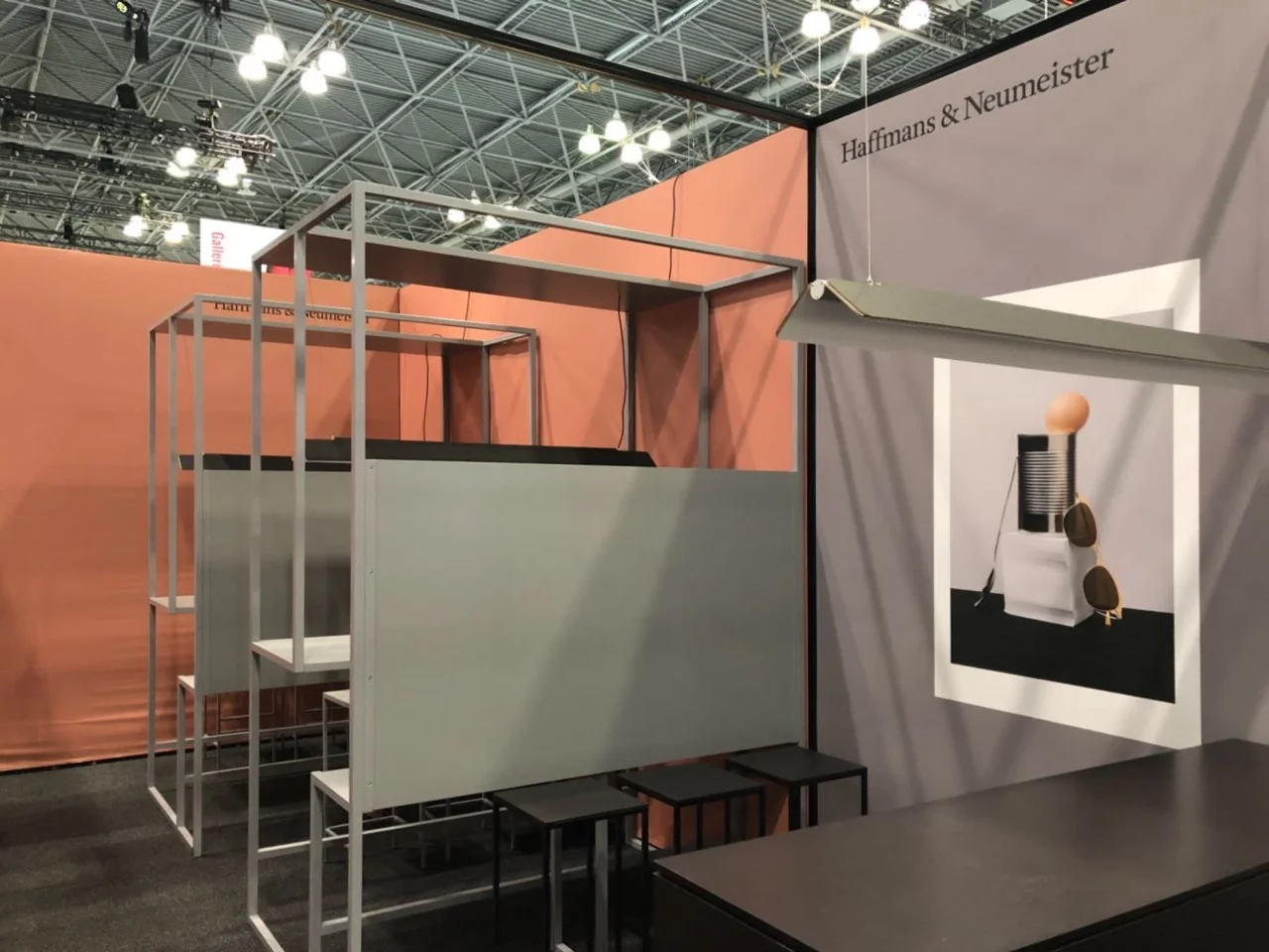 Beratungsbereich auf dem Messestand in warmen Rot- und neutralen Grautönen.