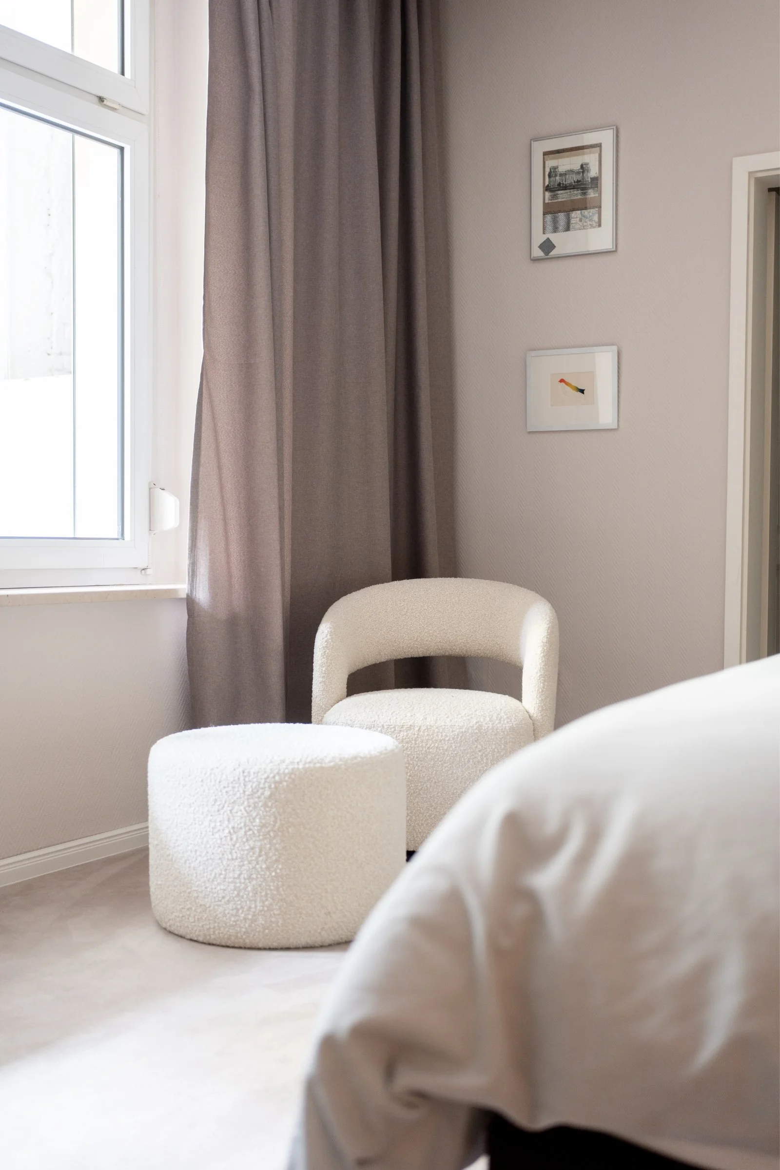 Weiche Materialien und sanfte Farben vom Innenarchitekten gezielt für ein Damenschlafzimmer ausgewählt. Ein kuscheliger Sessel in Bouclé-Stoff lädt zum Lesen und Entspannen ein.