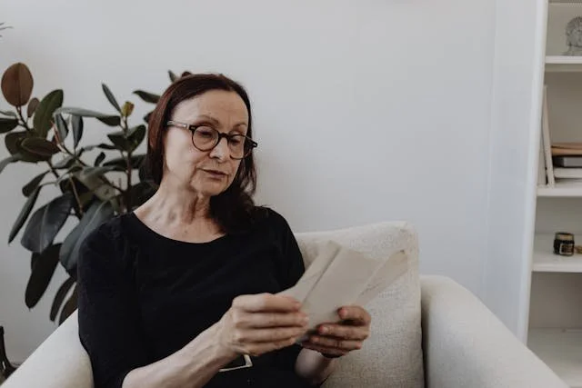 woman in black top looking at sheet of  paper