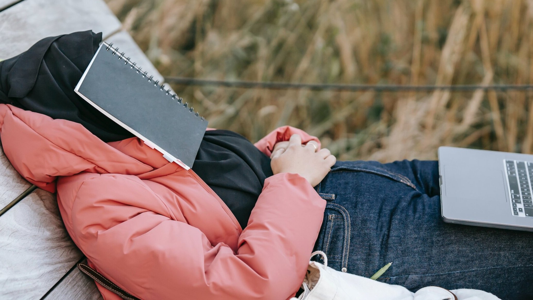 woman lying book covering face