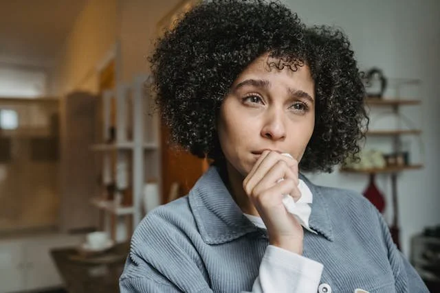 woman holding tissue thinking