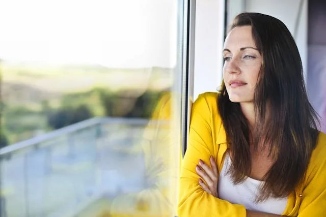 woman leaning against window smiling