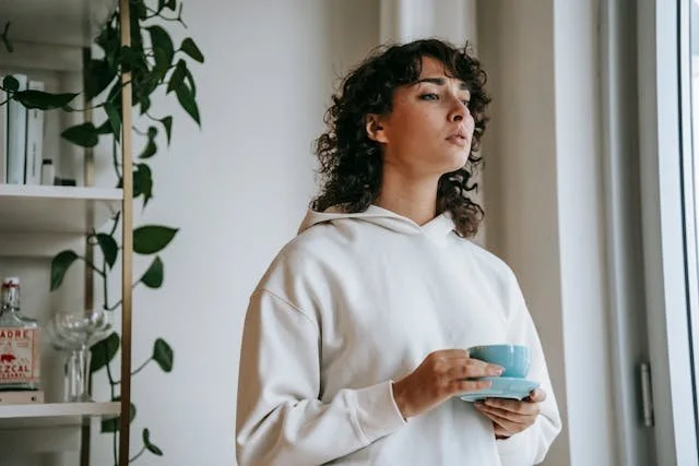 woman with tea cup looking thoughtful