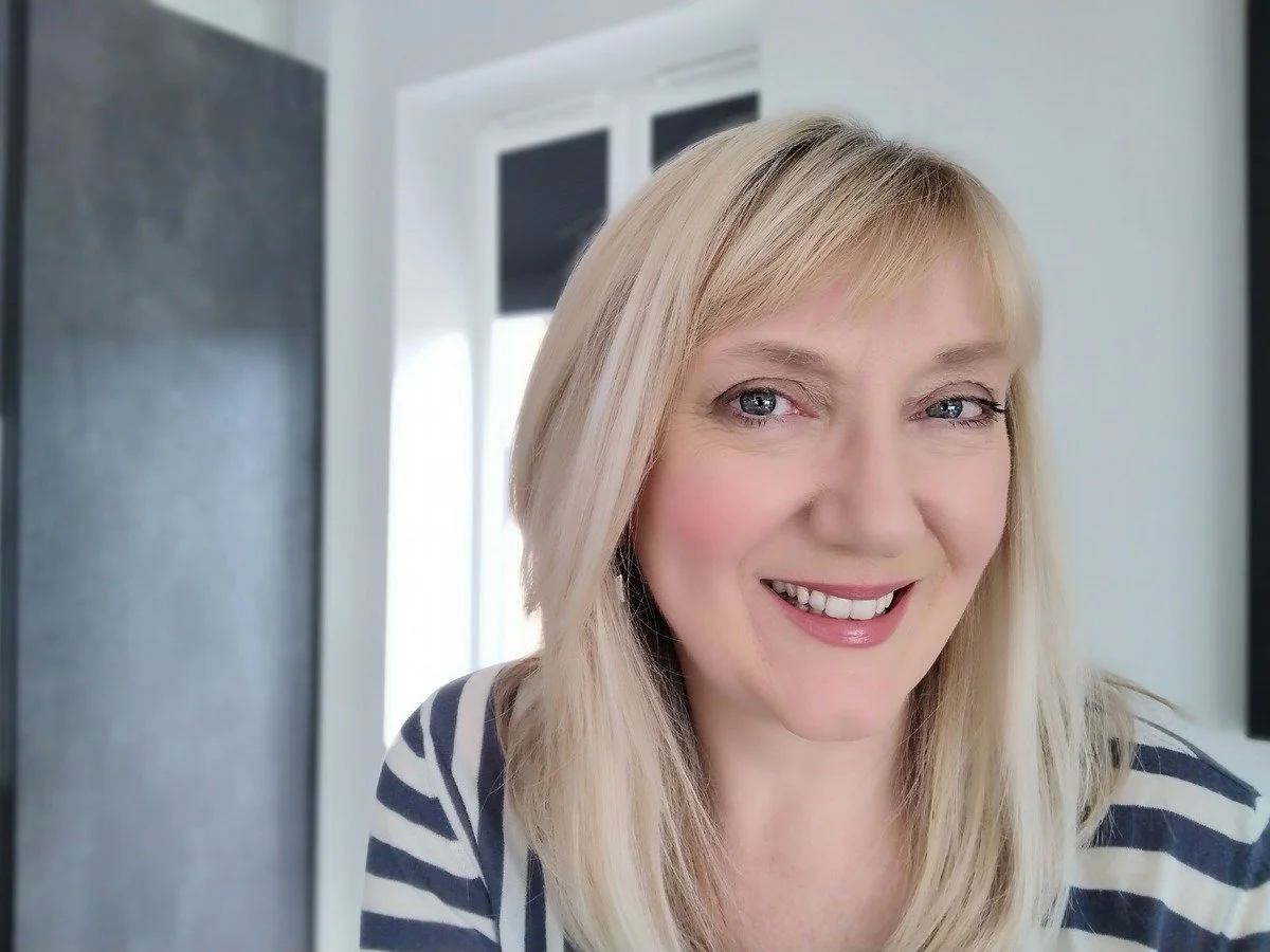 blonde haired woman smiling wearing striped top