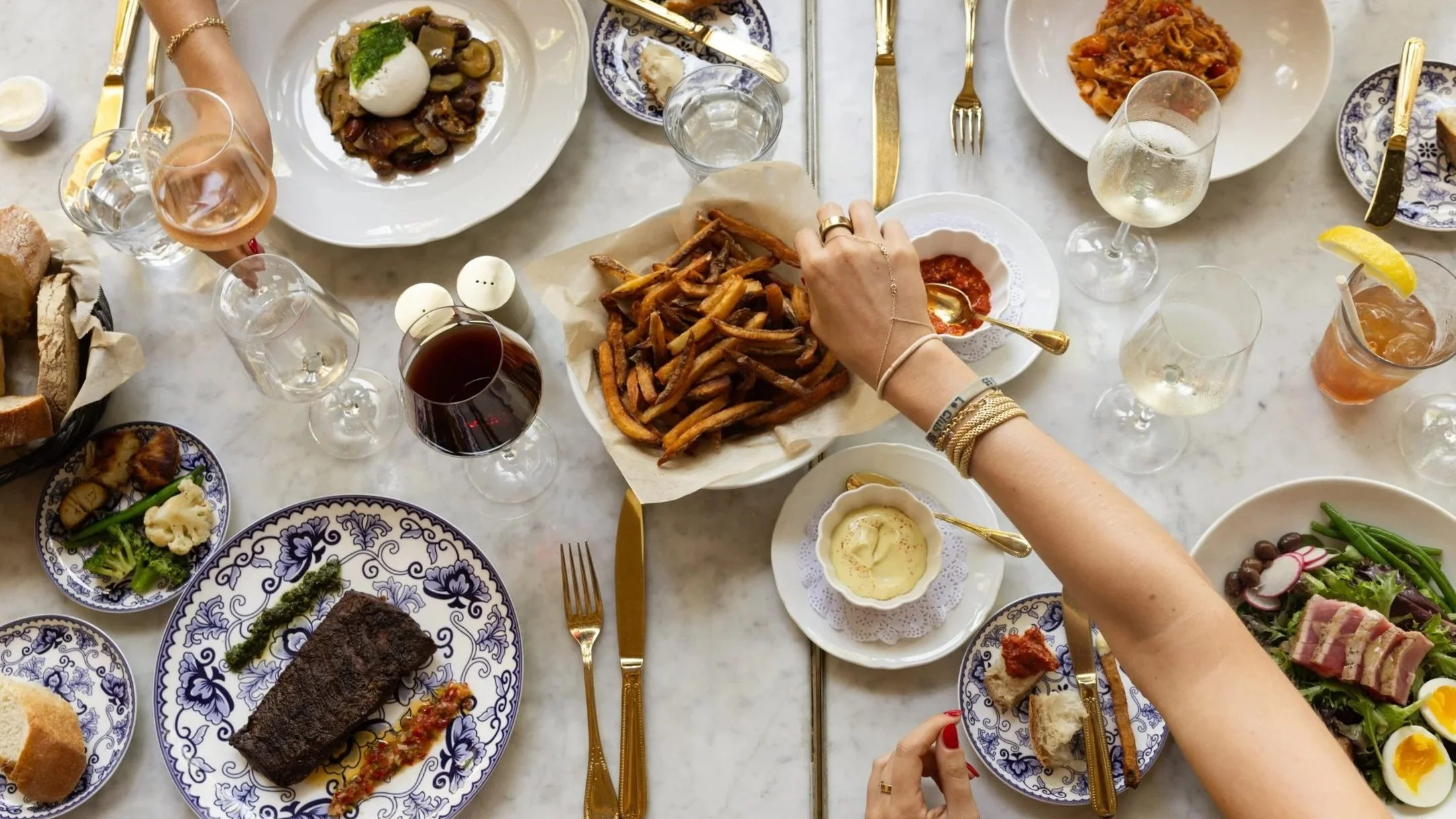 Plated seasonal dishes at Bianca restaurant in Culver City, including a grilled steak, vegetables, and shared plates set for dining.