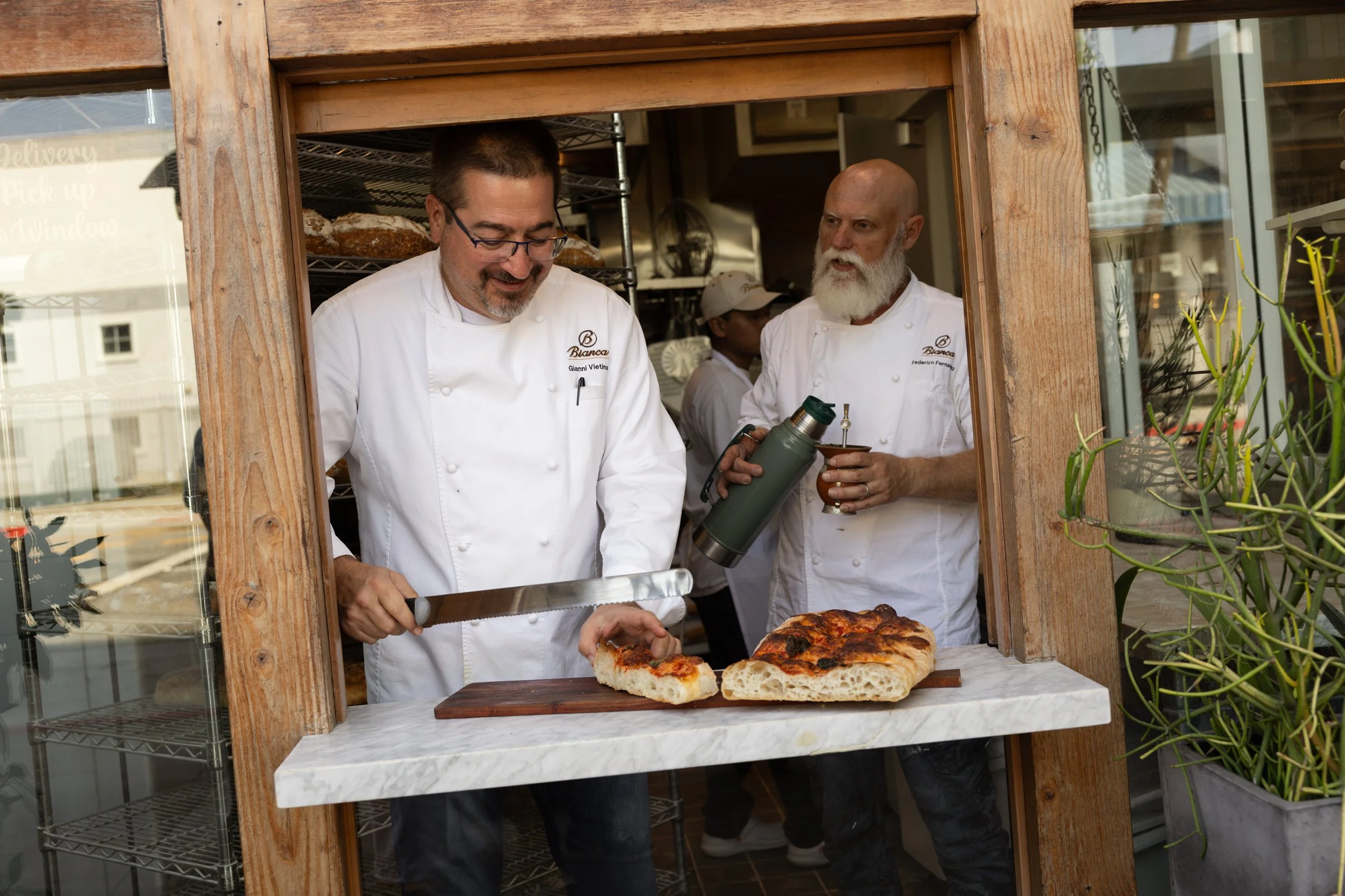 Chefs Gianni Vietina and Federico Fernandez preparing bread and dishes in Bianca’s open kitchen in Culver City.