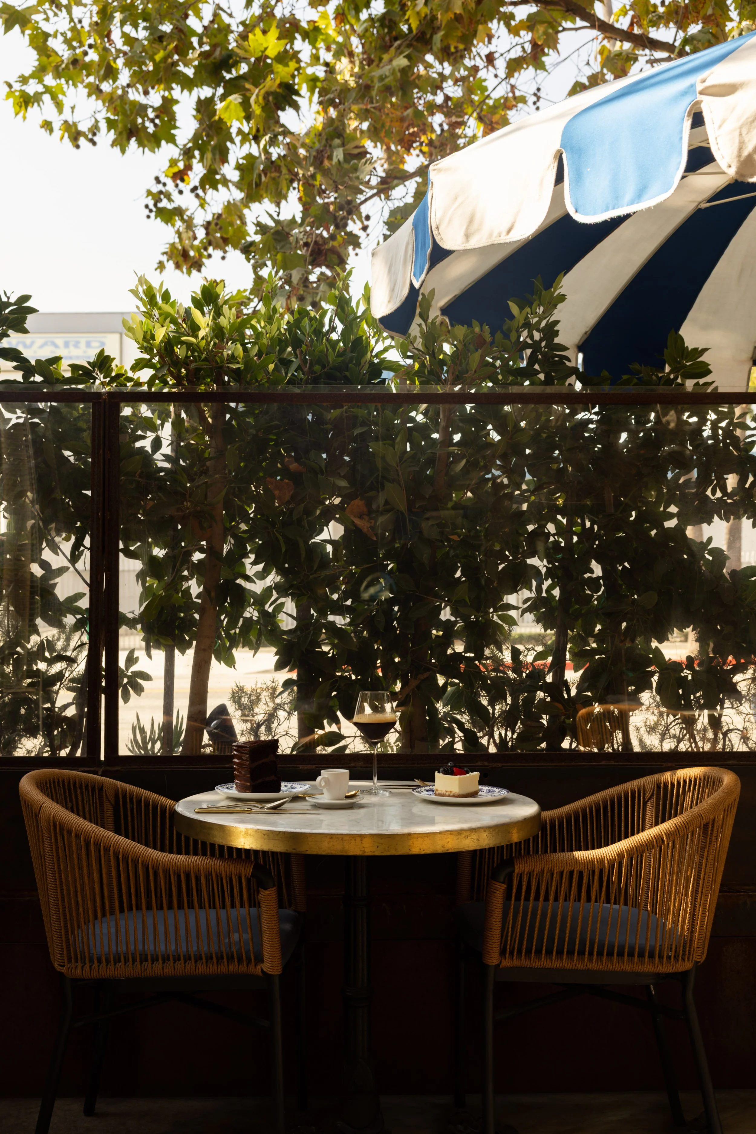Outdoor patio dining at Bianca restaurant in Culver City with shaded seating and a relaxed garden setting.