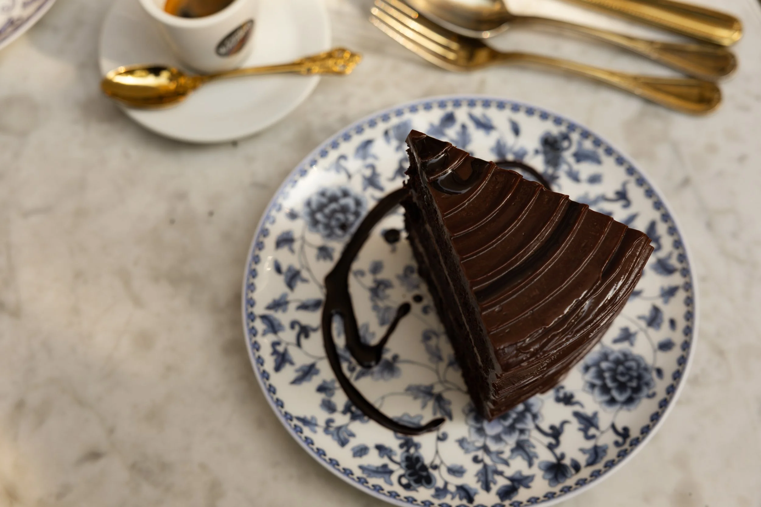 Slice of Grandma's Chocolate Cake served at Bianca bakery in Culver City on patterned china.