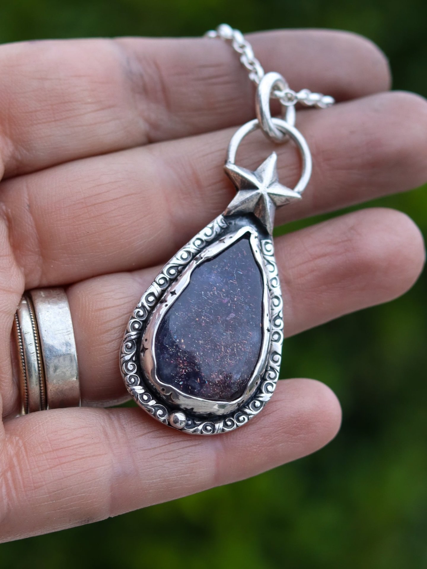When the Stars Align 

A celestial handcrafted sterling silver pendant cradles an Iolite with captured flecks of starlight scattered across her like a midnight sky, framed in hand stamped  silver like ancient constellations.

Topped with a guiding st