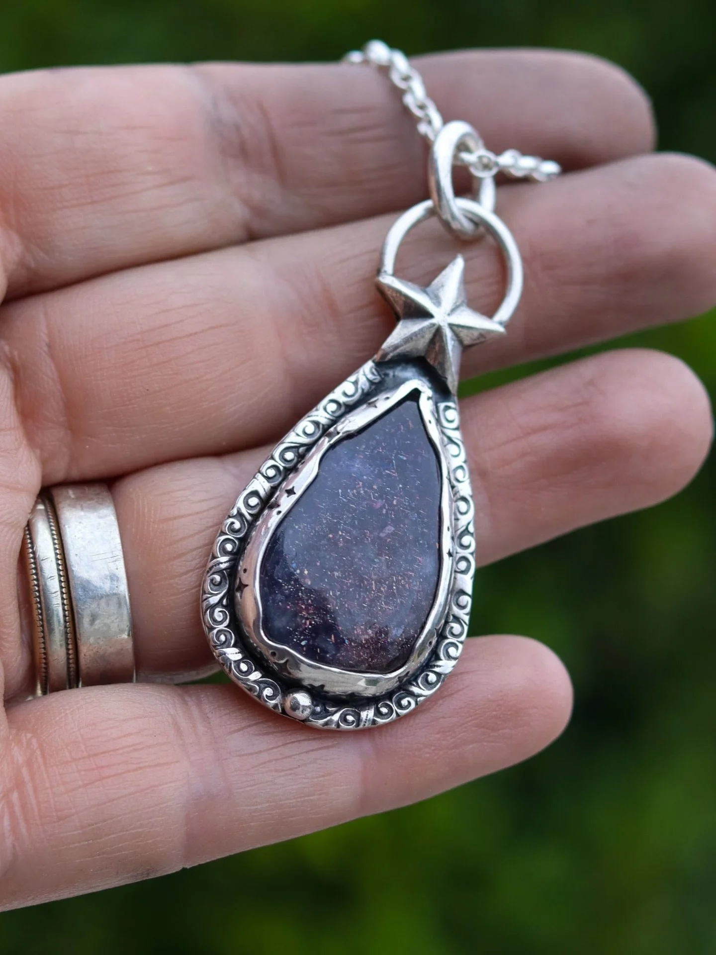 When the Stars Align 

A celestial handcrafted sterling silver pendant cradles an Iolite with captured flecks of starlight scattered across her like a midnight sky, framed in hand stamped  silver like ancient constellations.

Topped with a guiding st