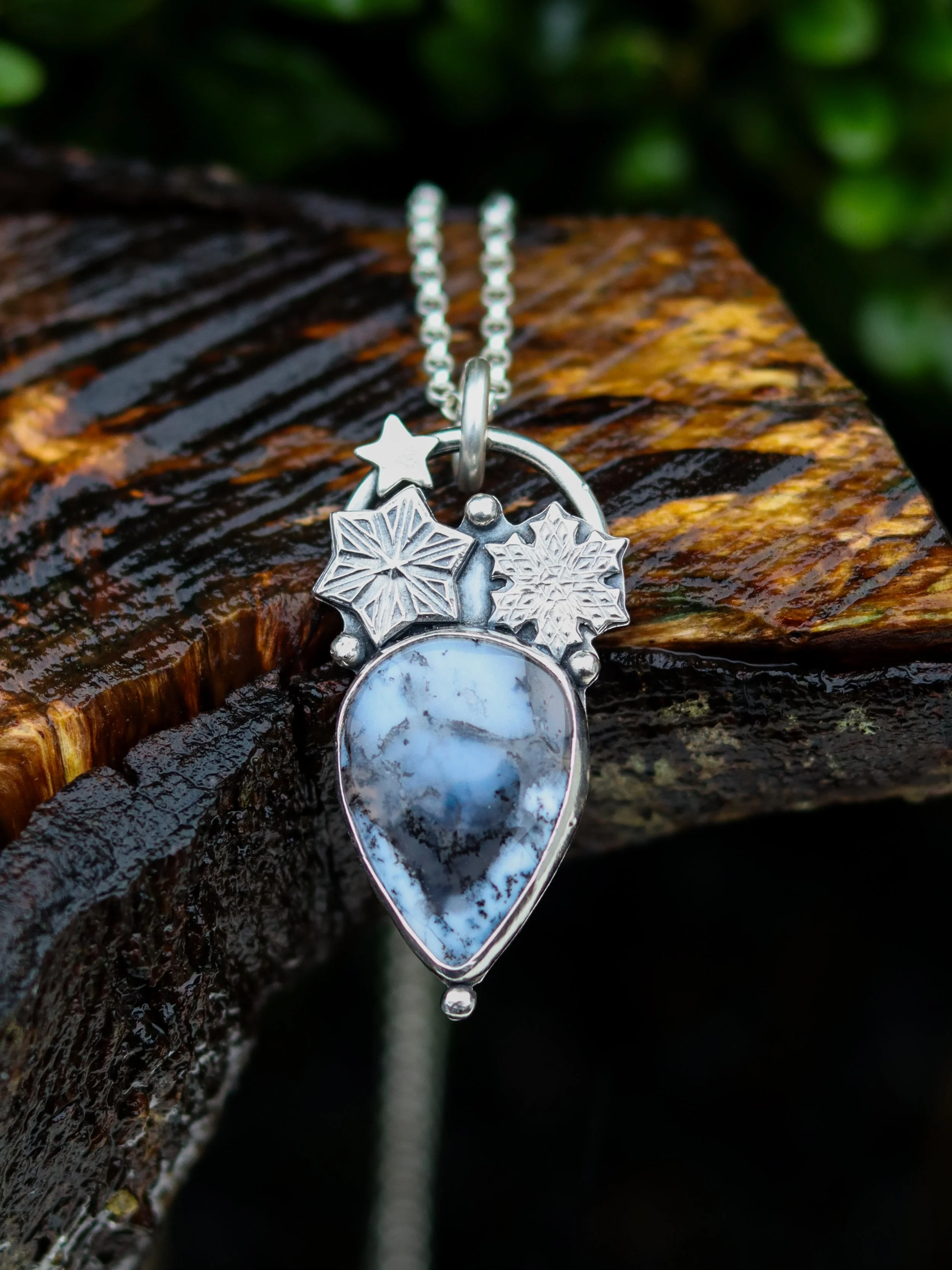 teardrop pendant shaped to resemble an ice shard with a beautiful gem inlaid. also featuring two snowflakes and a star made of silver. new pendant on a storyteller chain by Gemheaven Jewellery