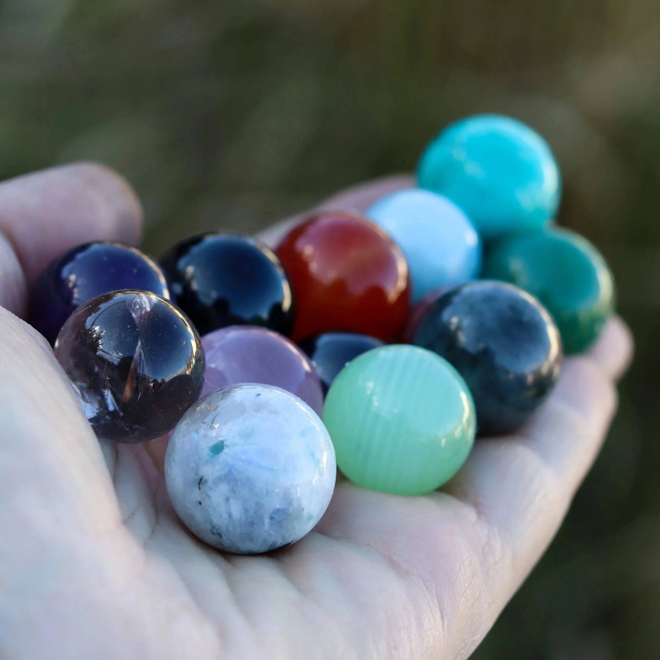 selection of crystal ball spheres laid in a open hand