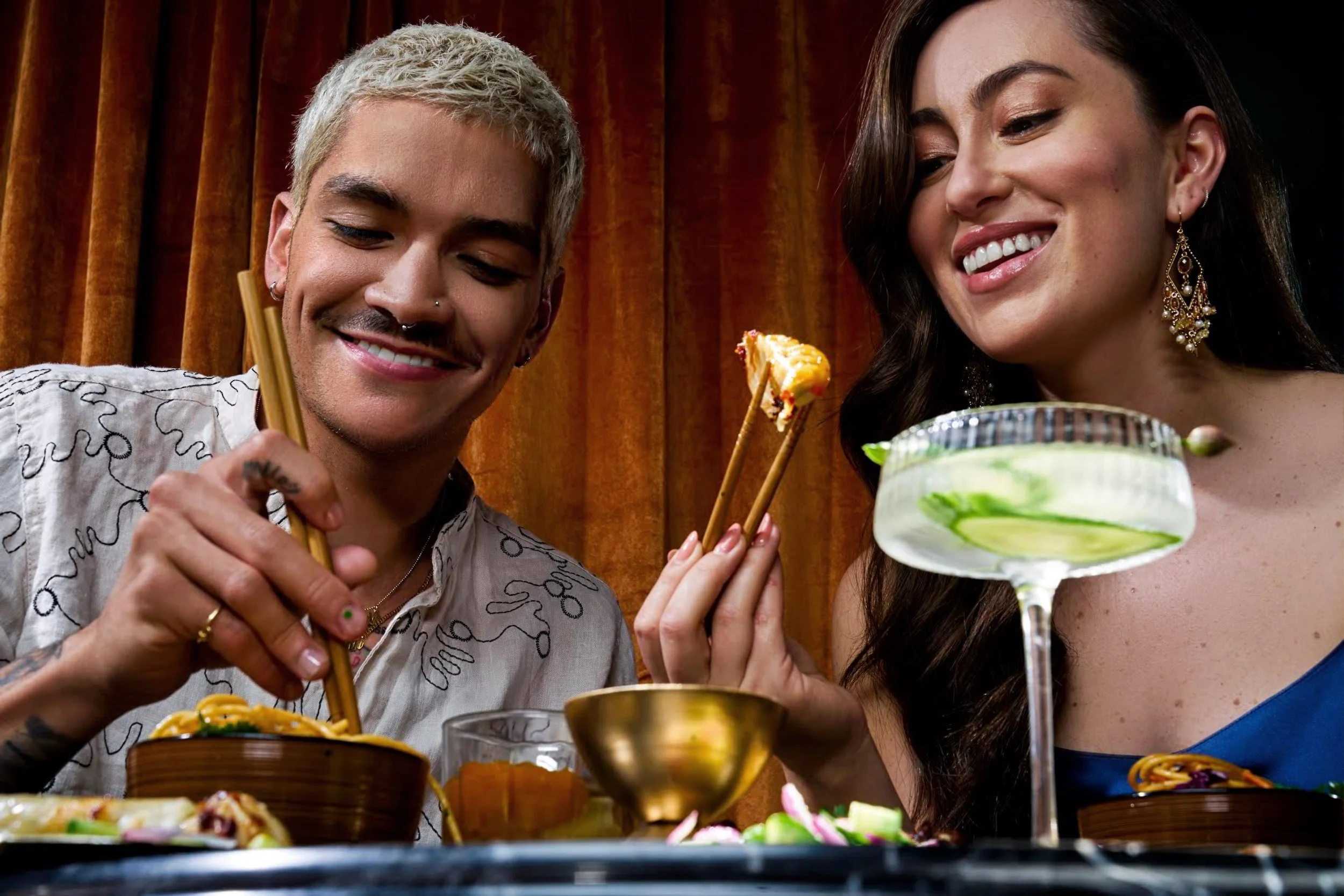 a couple is sitting at a dinner table in a restaurant eating asian food