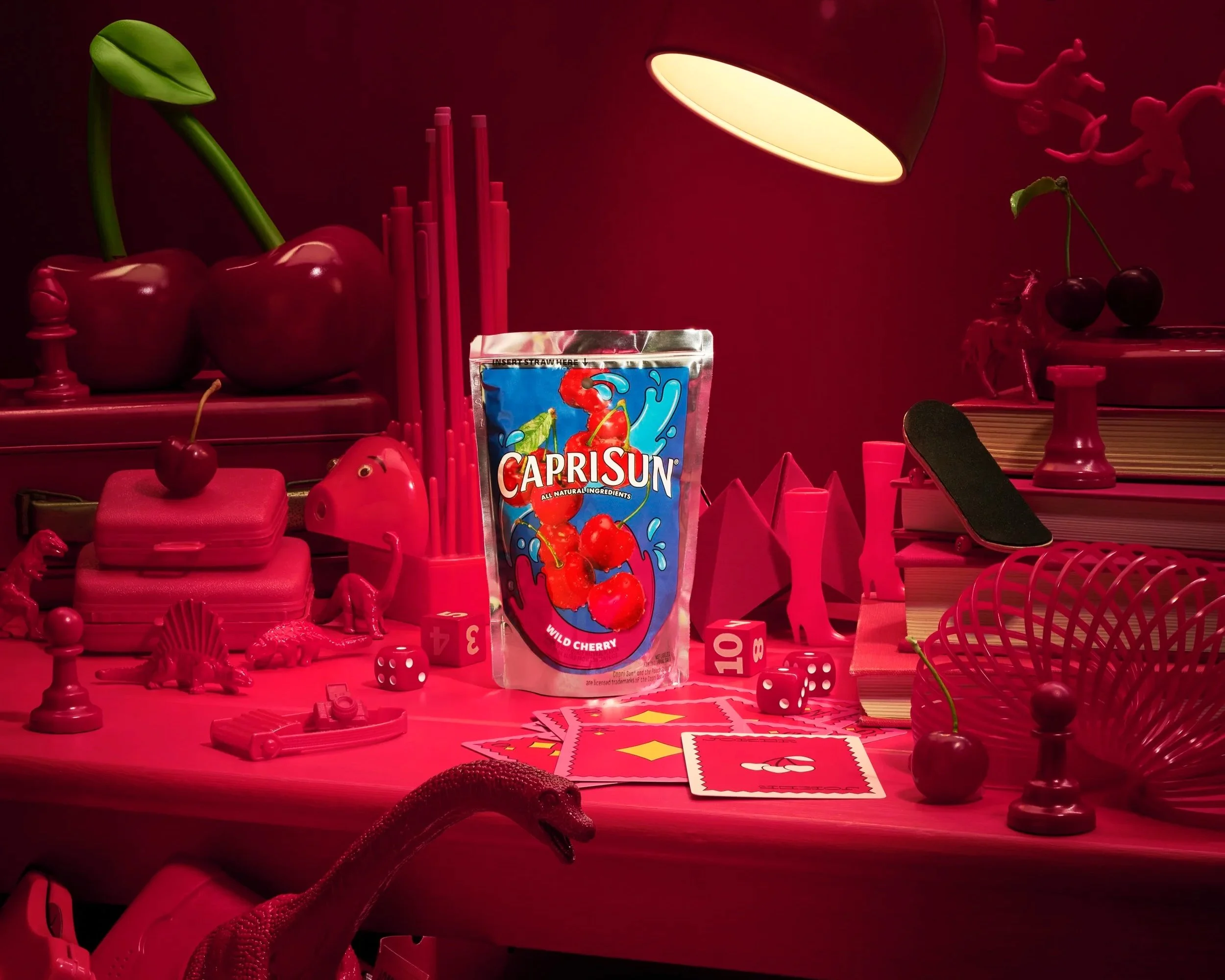 Capri Sun juice pouch sitting in a cherry red environment surrounded by nostalgia toys from the 90's including a red pixar style lamp.