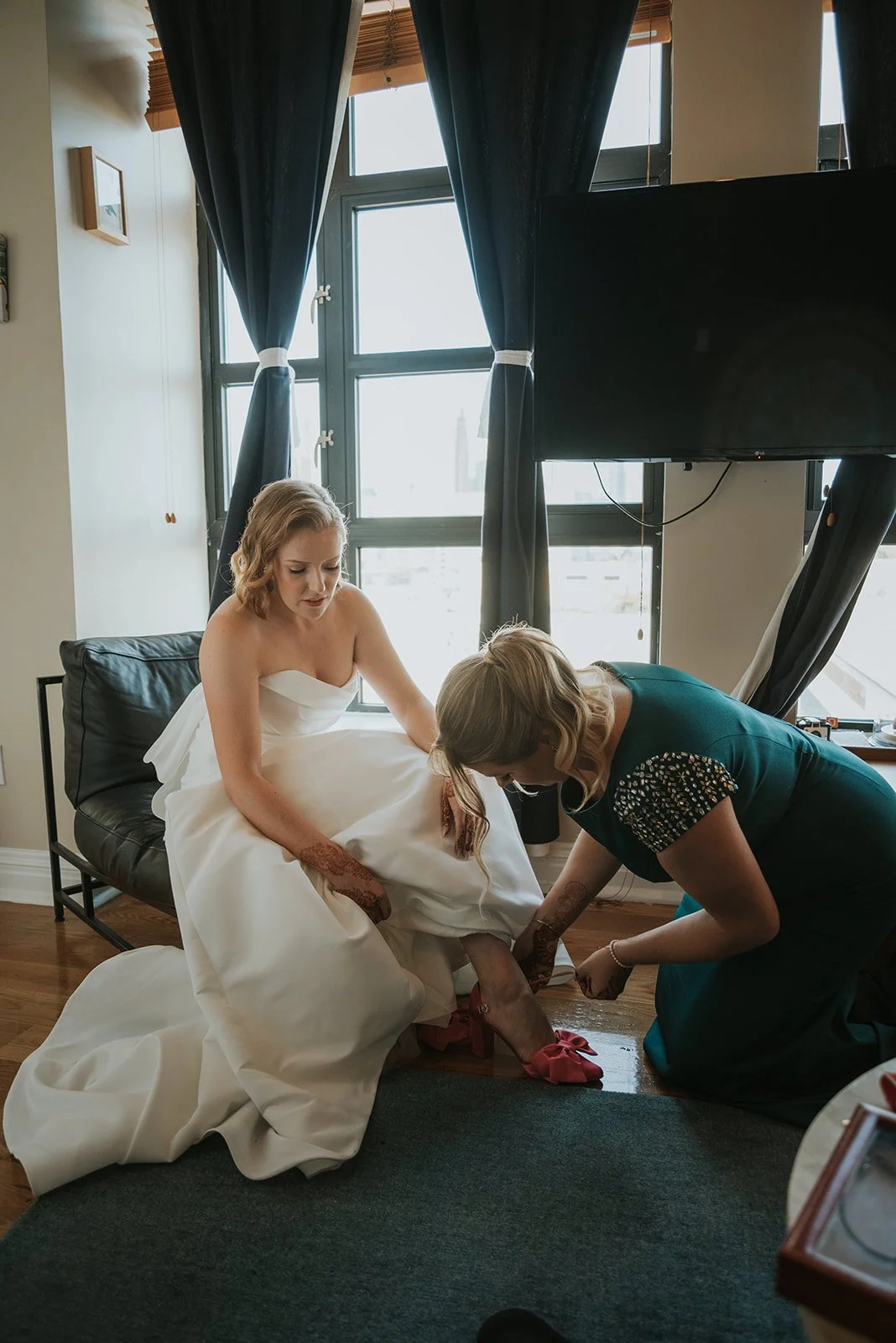 Mother of the bridge lacing brides shoe on wedding day.jpg