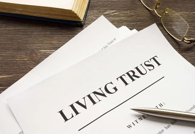 A living trust document with a pen and reading glasses