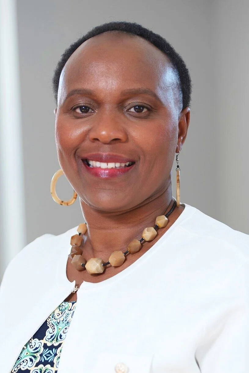 Cate Kuria smiling in a white blazer