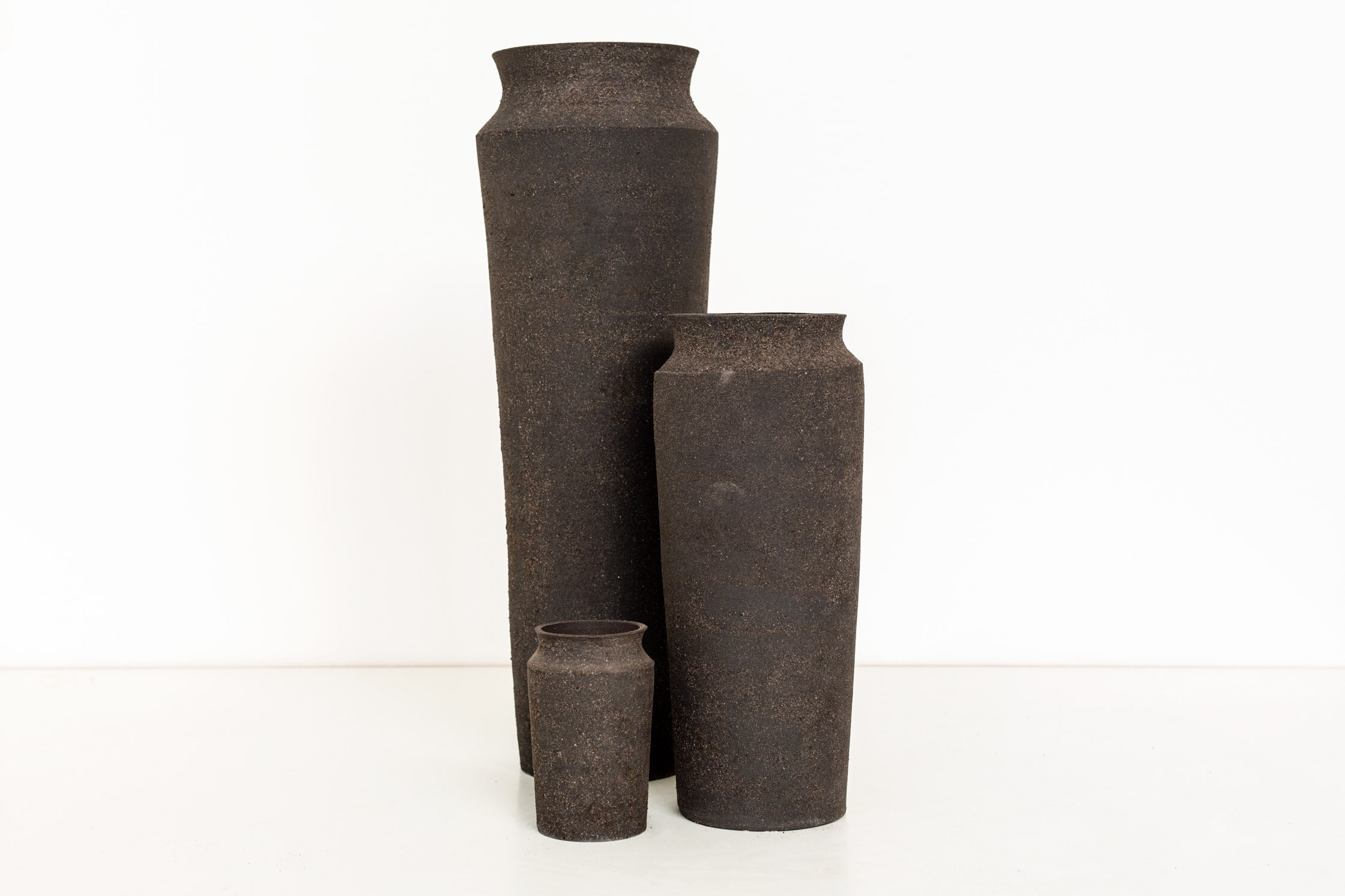   Three ceramic vessels by ceramic artist Kevin Callaghan. Made of toxin sludge from a radioactive tailings lake in Mongolia. Each vessel is proportioned as a traditional Ming vase and is made from the amount of toxic waste created in the production 