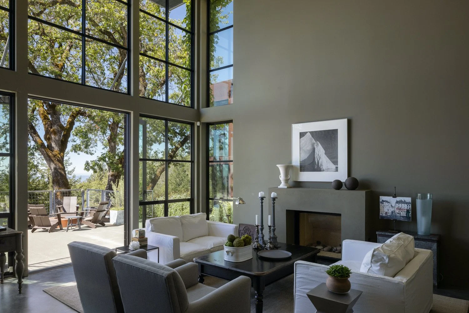 Capturing Sophisticated Spaces in this luxury home tour. Interior photography showcasing living room decor and high ceilings bonus high windows gazing out to greenery spaces.