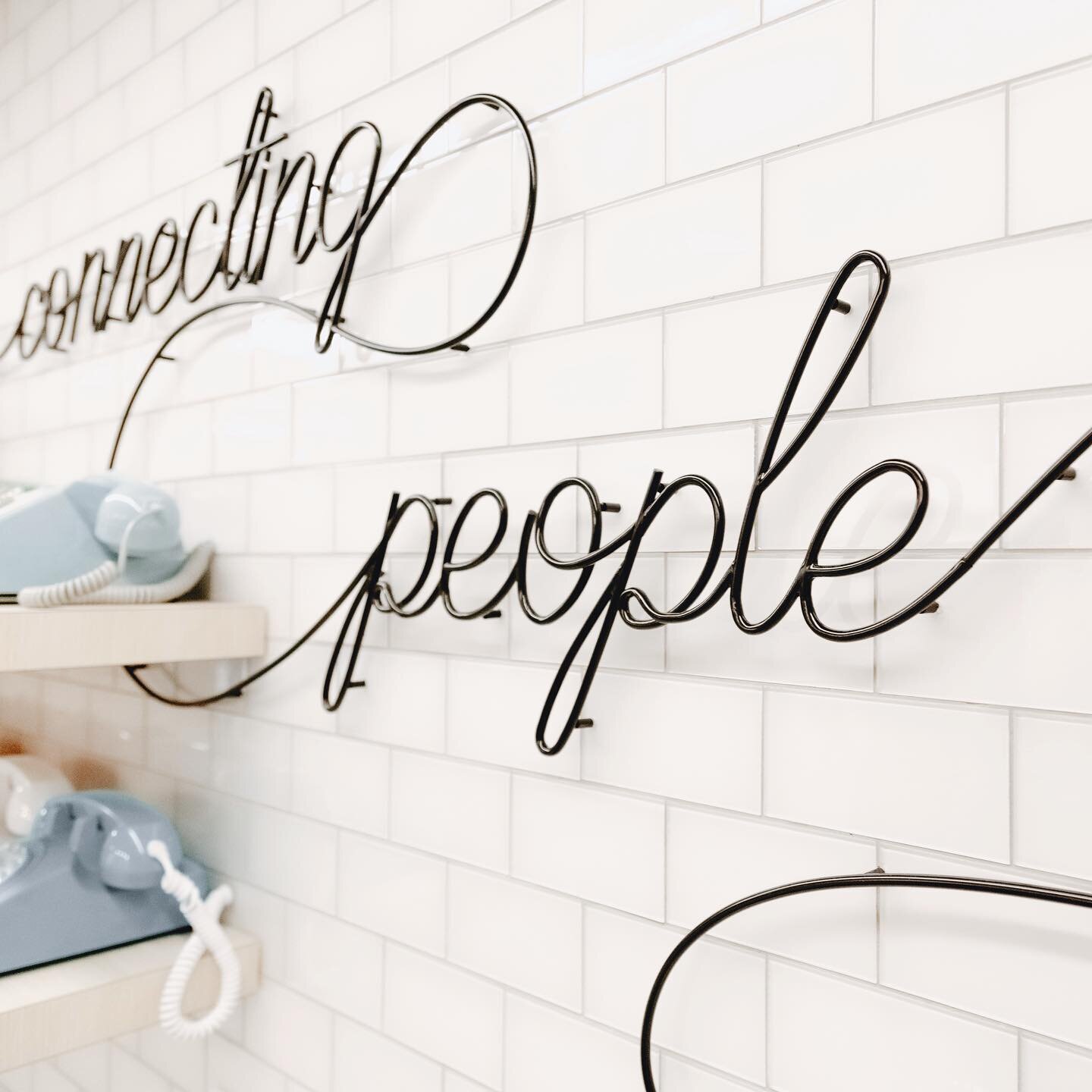 #Branding Spotlight 🌟 A colorful collection of rotary-style telephones serves as a nod to the heritage of @telhiocu as The Columbus Telephone Company. The phrase &quot;Connecting People Since 1934&quot; is wound throughout in copper tubing, alluding