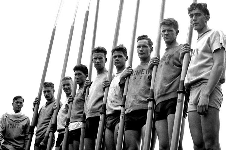  The never-defeated UW Varsity Eight (from left): Bobby Moch, Don Hume, Joe Rantz, George Hunt, Jim McMillin, Johnny WHite, Gordy Adams, Chuck Day, and Roger Morris. [Photo via University of Washington Magazine] 