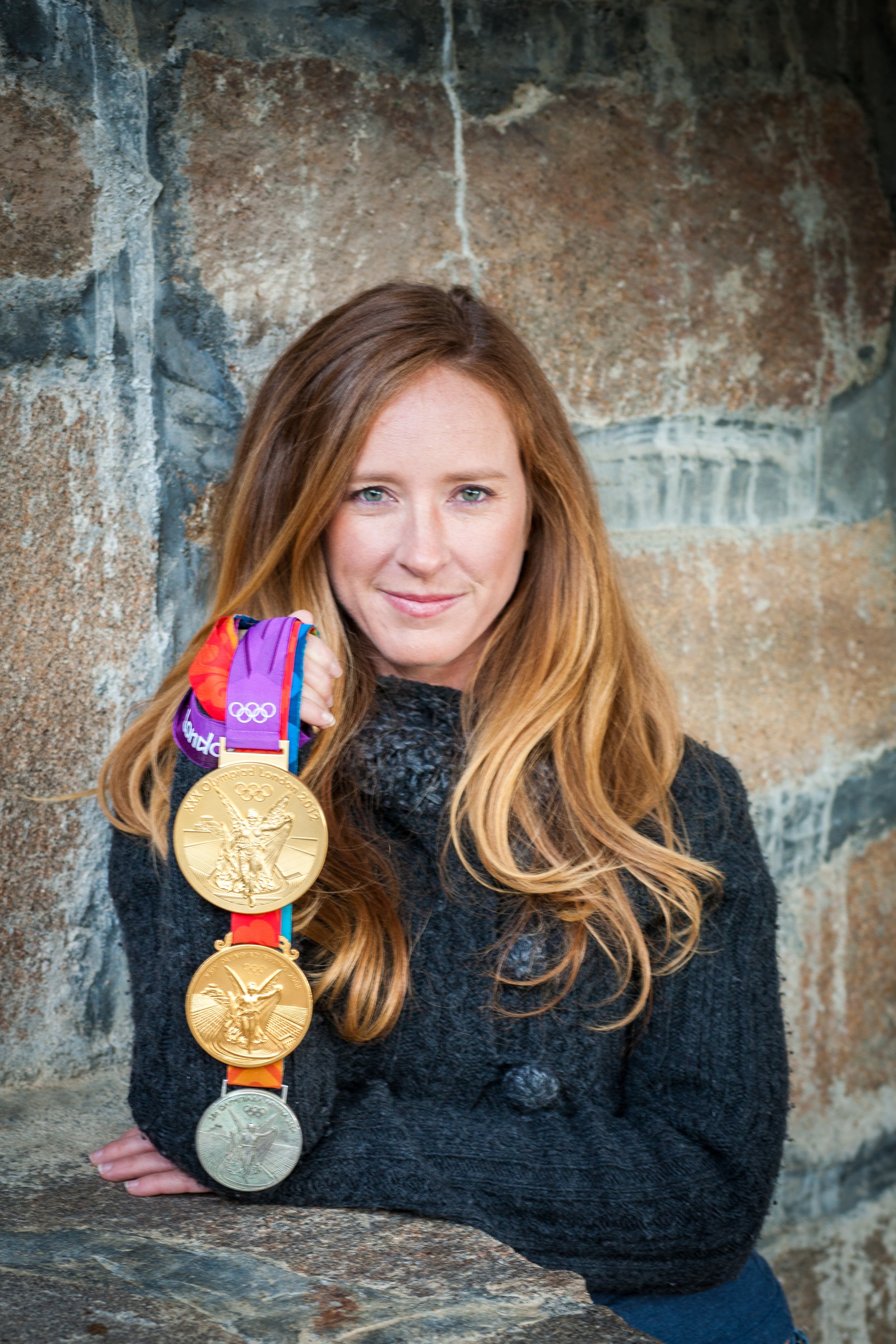 Mary Whipple shows off her Olympic medals from 2004, 2008, and 2012.