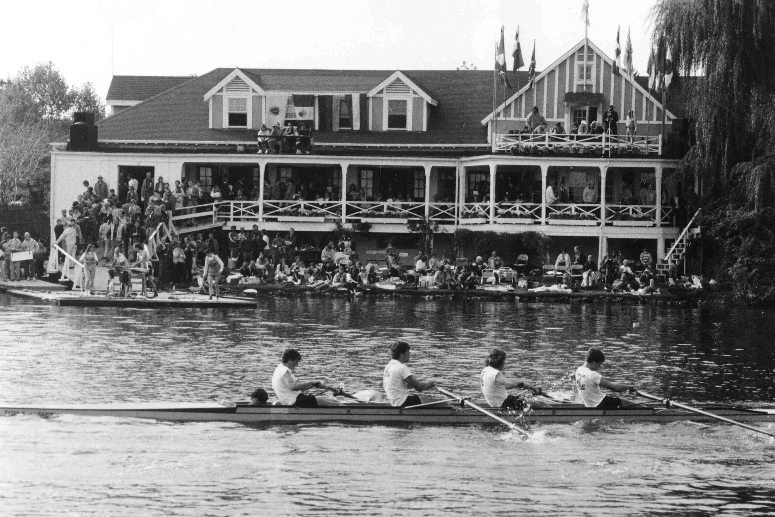 A crew passes by Cambridge Boat Club during the 1974 Head Of The Charles Regatta