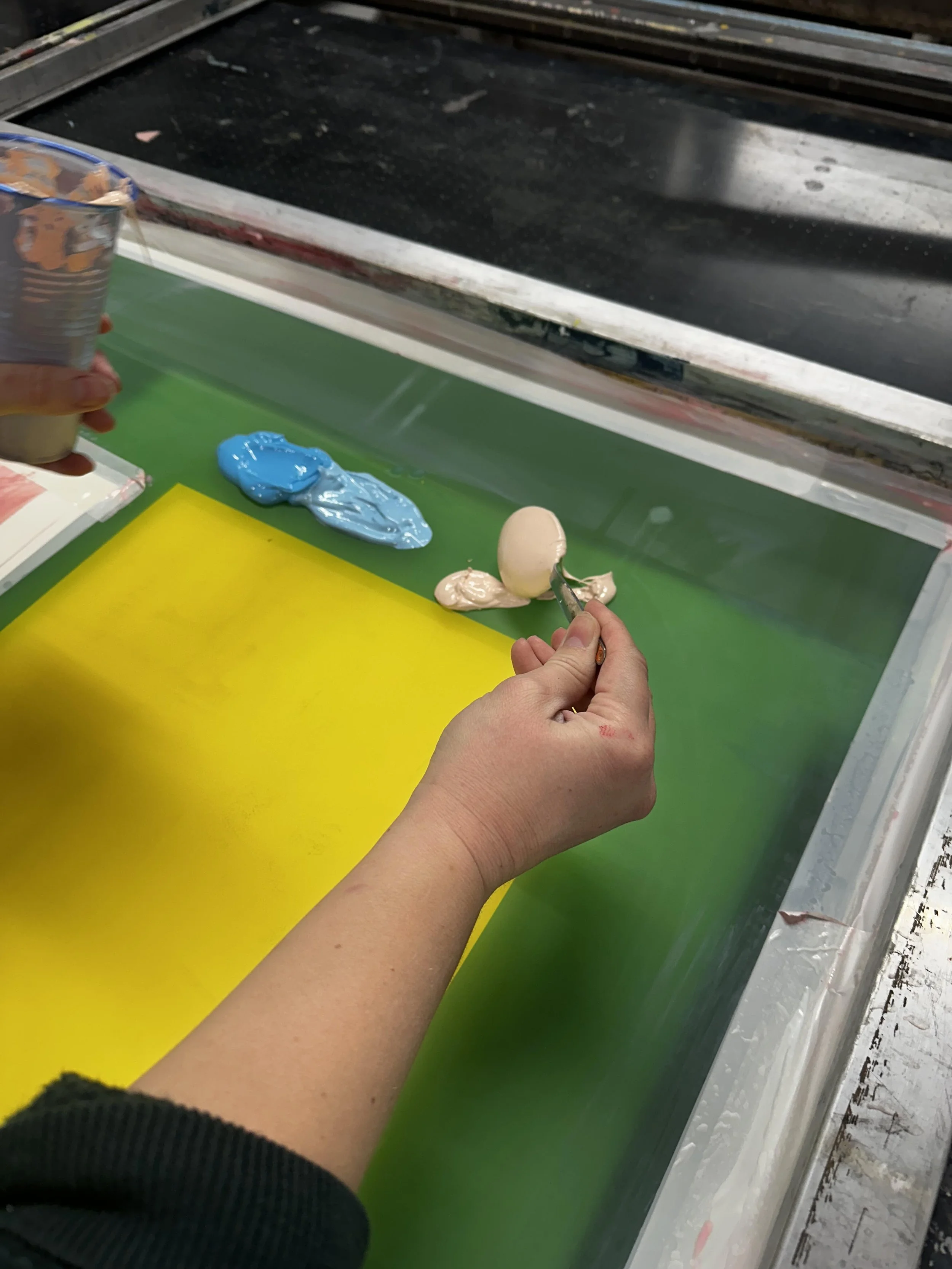 Carefully applying ink to the screen.