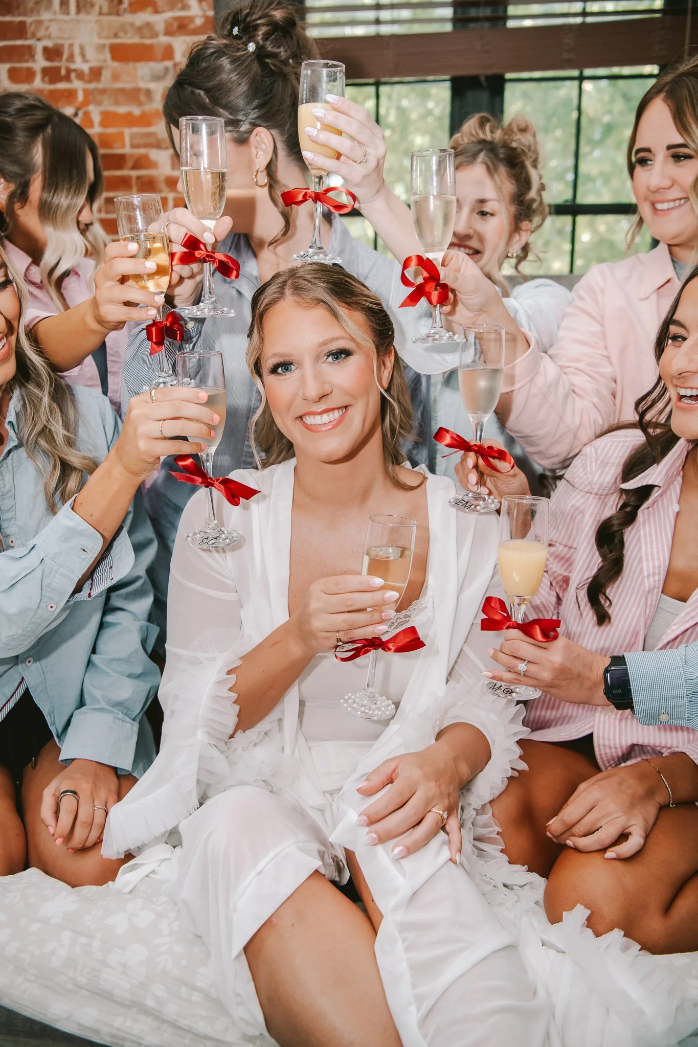 bride poses with bridesmaids as they get ready for the ceremony at Schwarz Barn in Illinois Photographed by Julia Spencer of Jewels Photo Co.
