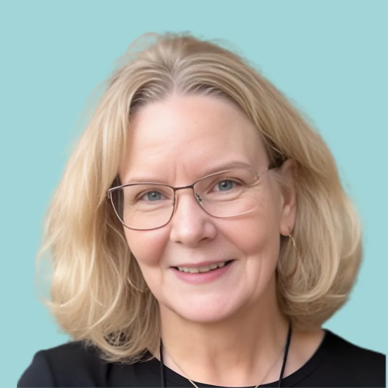 Portrait of a smiling woman with blonde hair wearing glasses and a black top against a gray background.