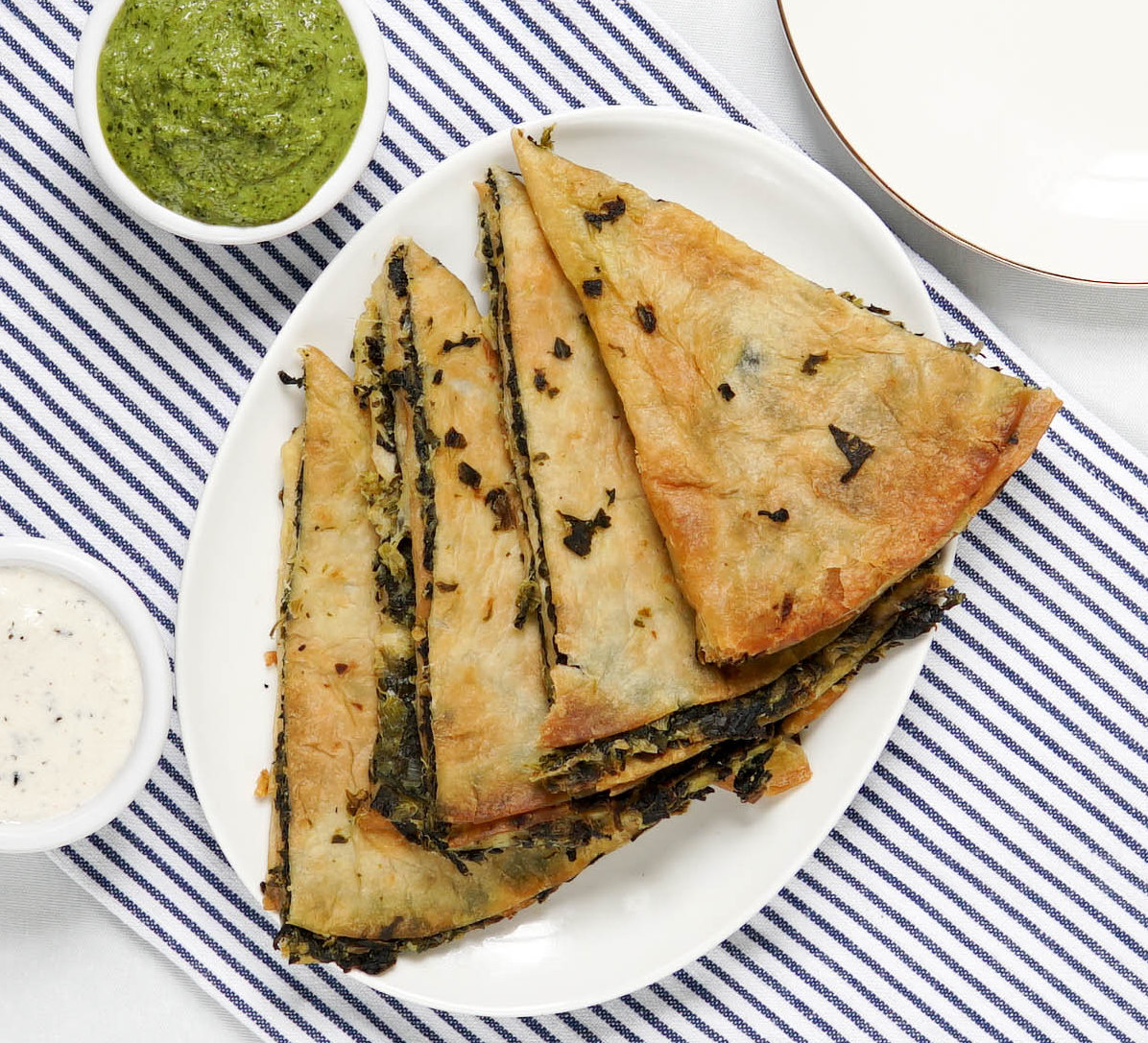  A plate of vegan stuffed flatbread with sauces 