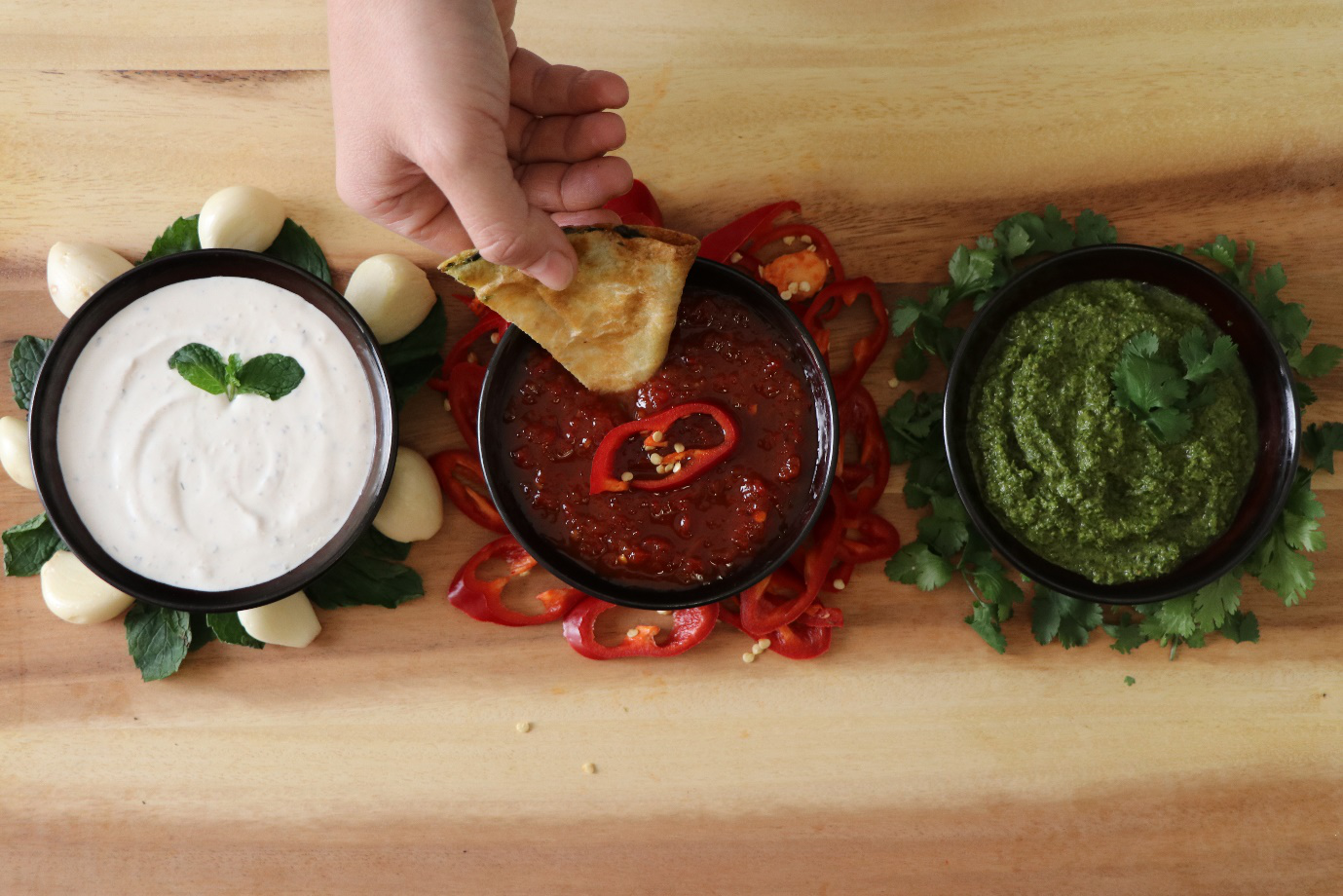 A person dipping vegan flatbread in sauce 