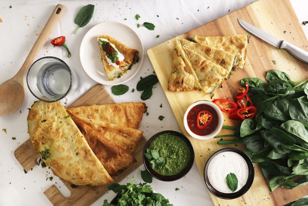 A couple of flatbread placed on a cutting board.