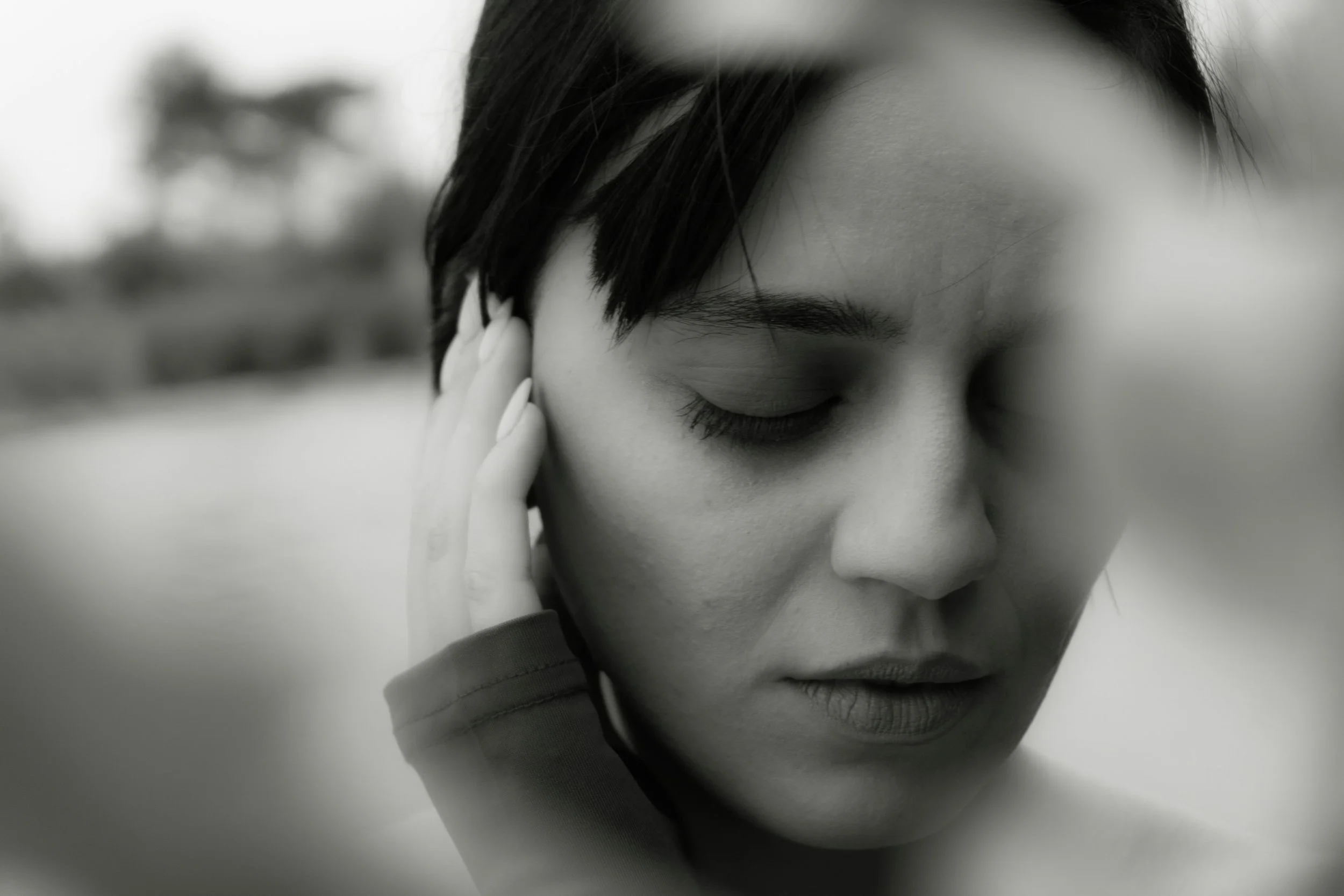 Woman with eyes closed resting her hand near her face in a quiet, self-attuned moment — somatic therapy in Burnaby, BC