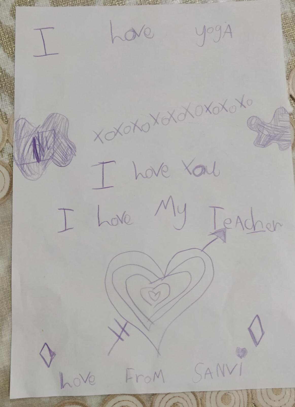 Child's drawing with "I love yoga," "I love you," "I love my teacher," hearts, and shapes.