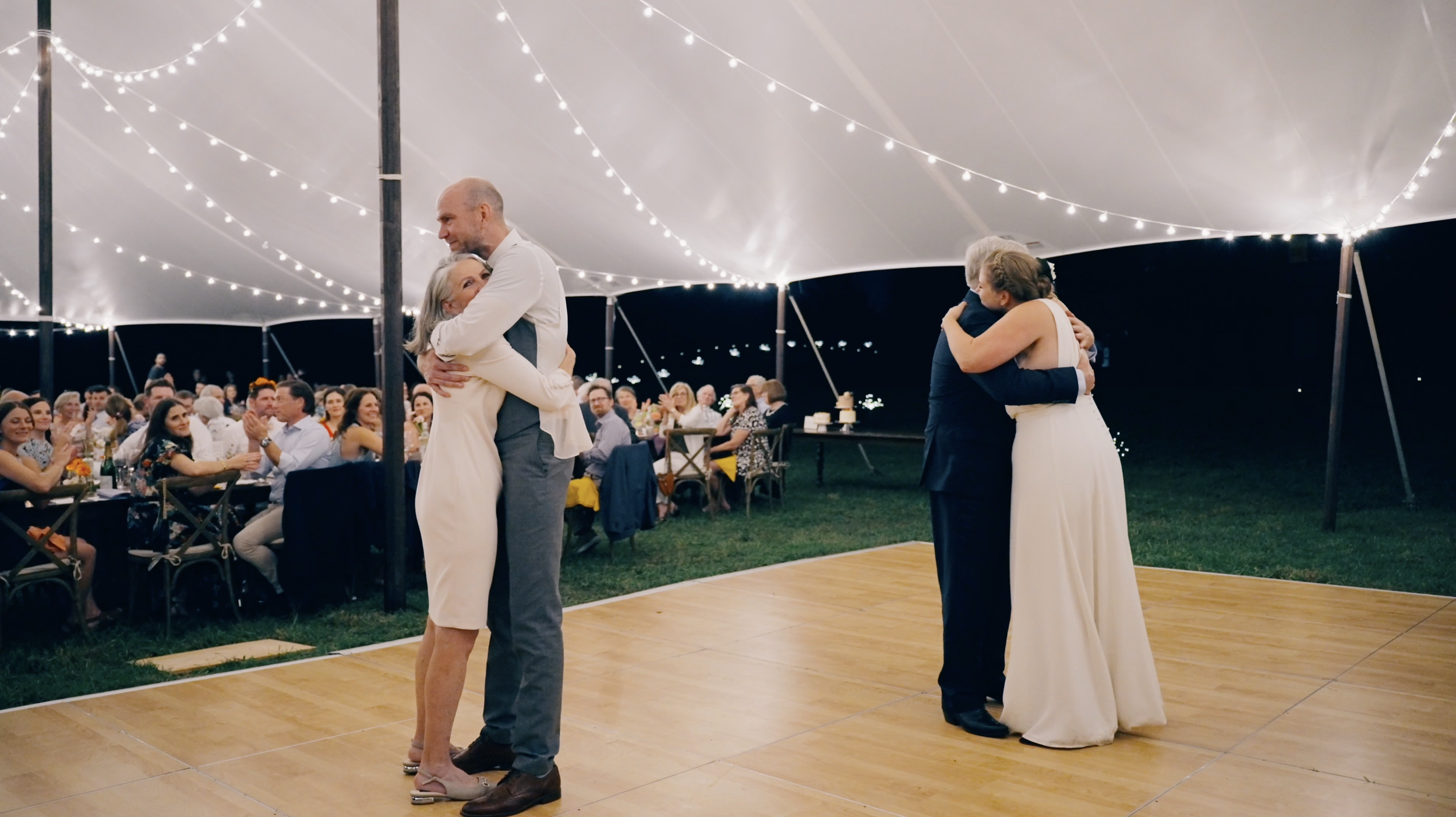 First dances wide shot of bride and dad and groom and mother.png