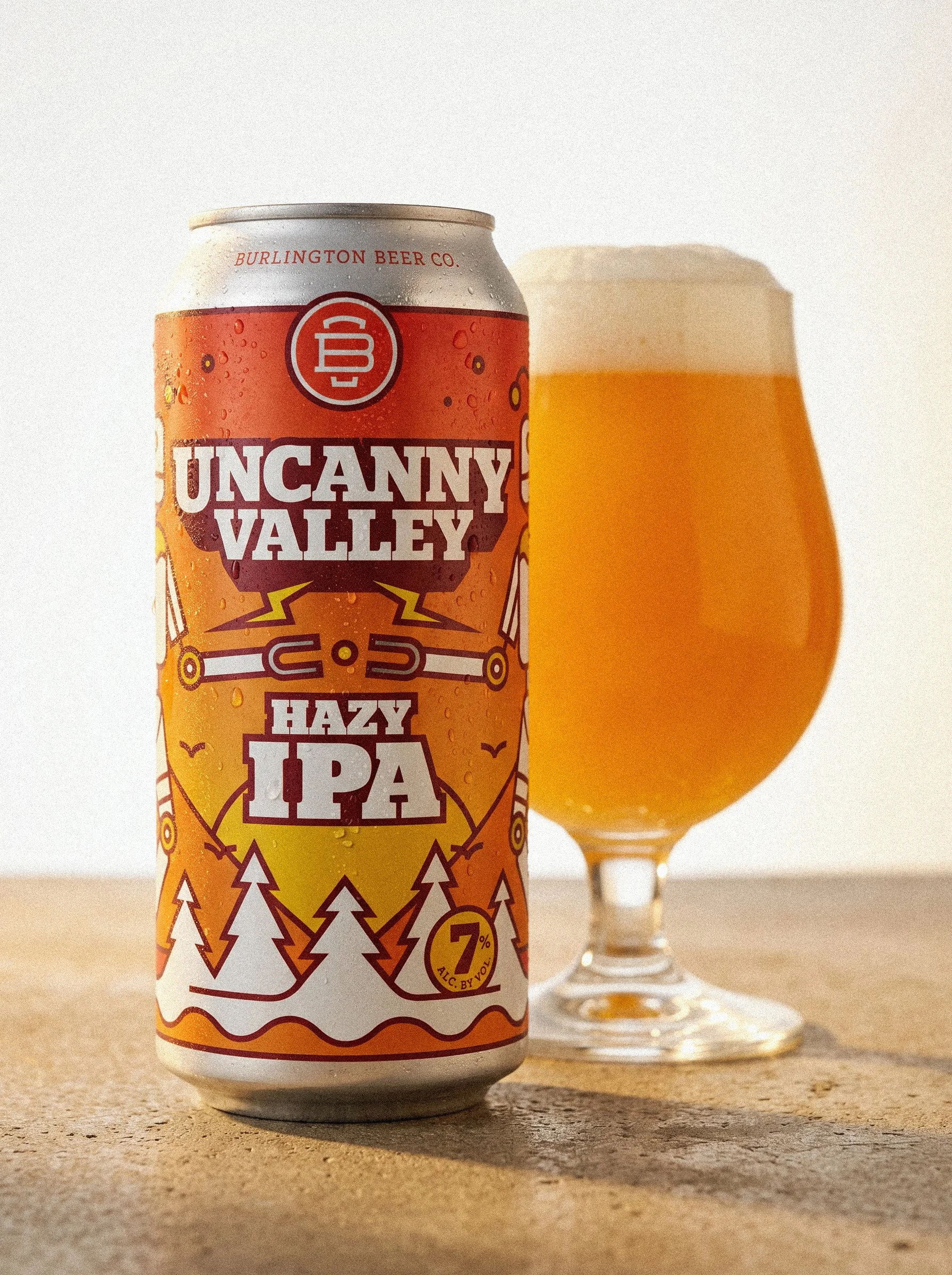 Uncanny Valley Hazy IPA can beside a freshly poured beer