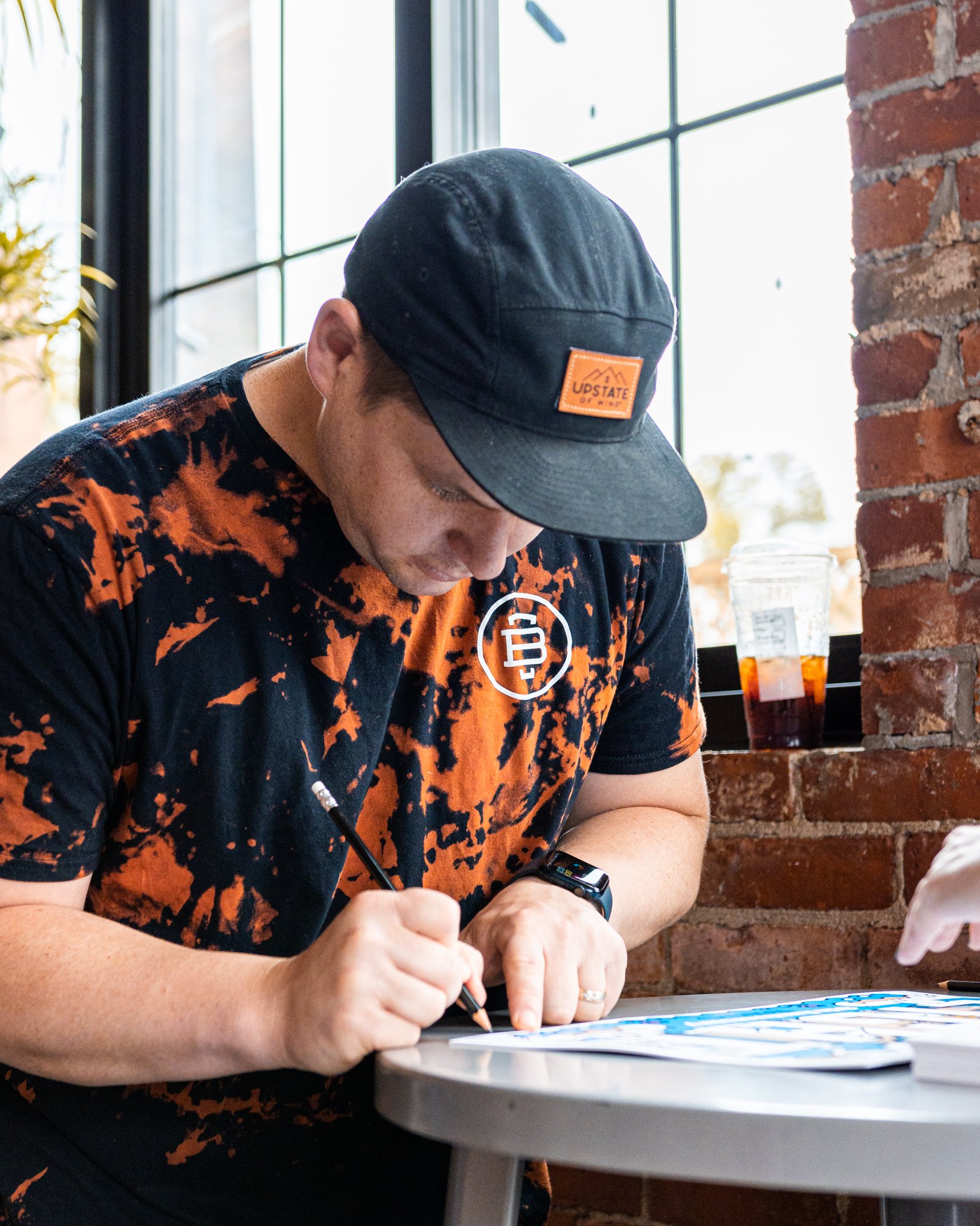 Tim Fealey drawing at a table in the Burlington Beer Co. taproom, May 2022.