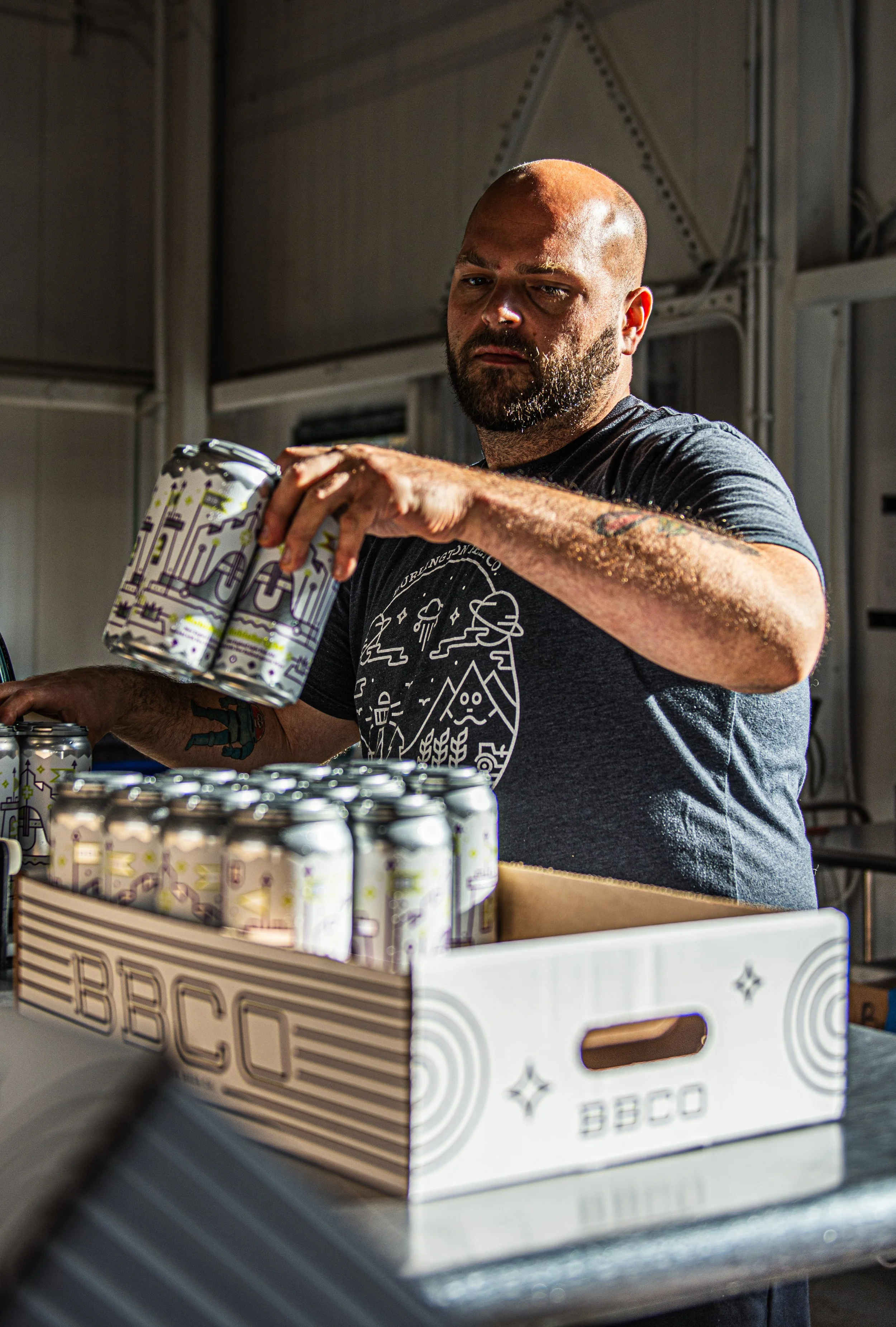 A Burlington Beer Co. team member packs cans into a case in 2021.