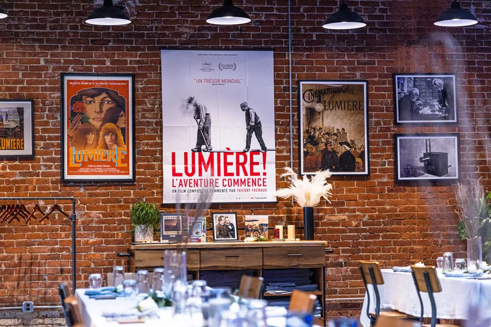 Tables set for Café Lumière beneath the Lumière display, March 2022.