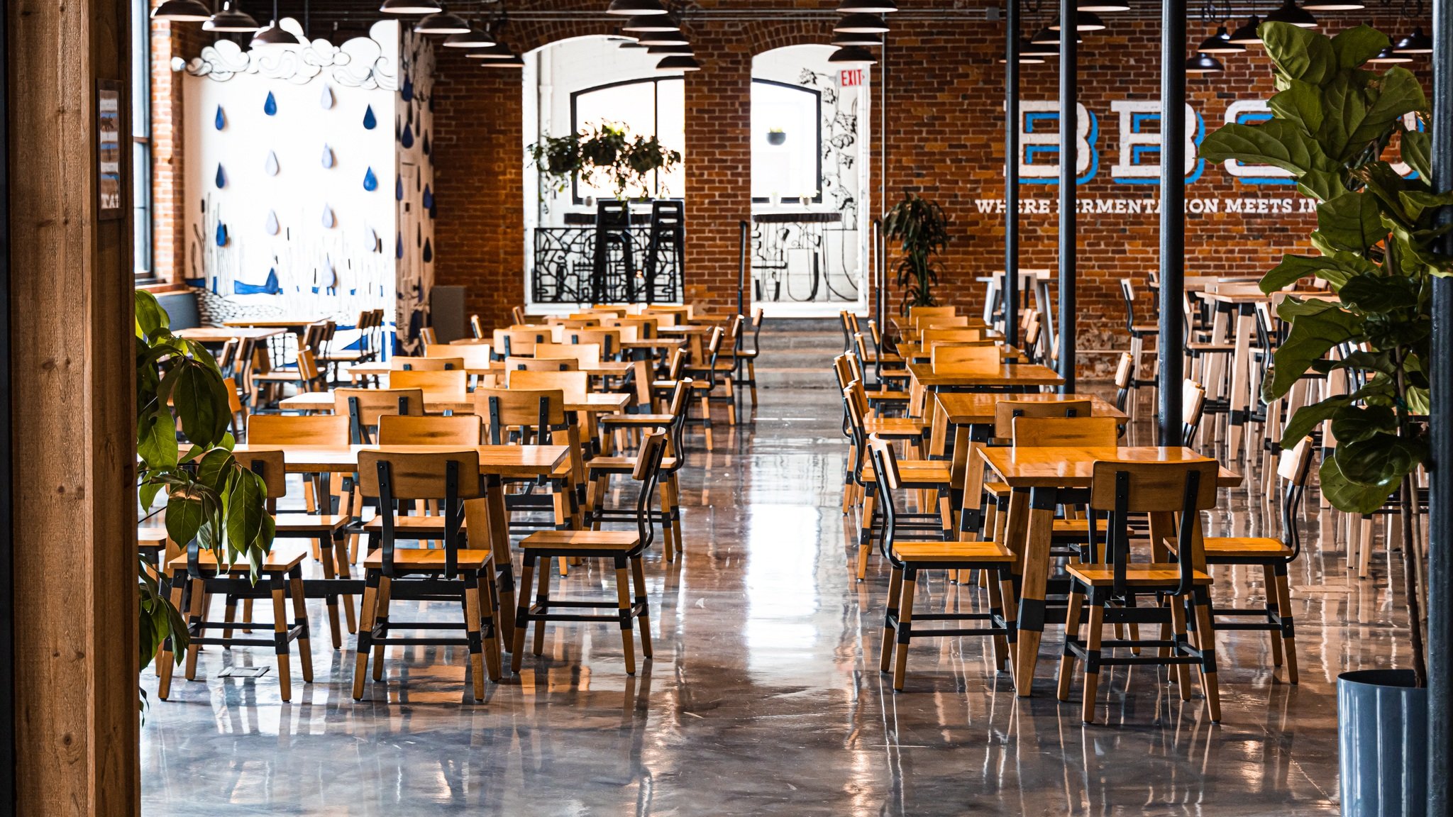 Sunlit dining tables and exposed brick at Burlington Beer Co.
