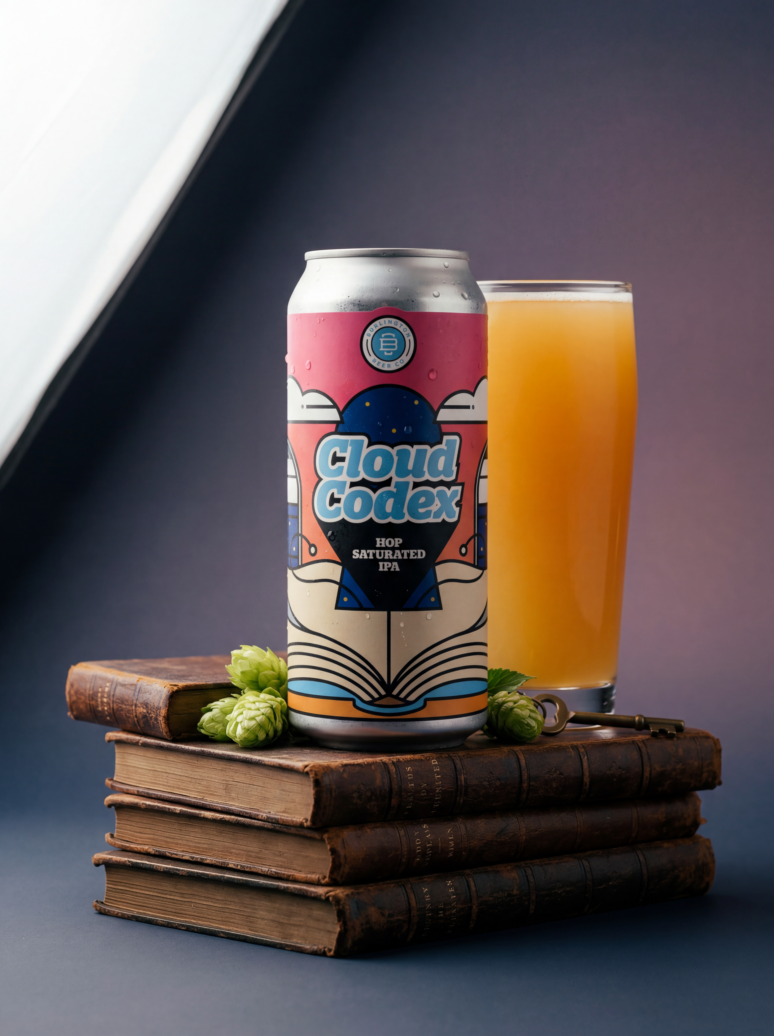 Cloud Codex Hop Saturated IPA can and poured beer beside stacked books