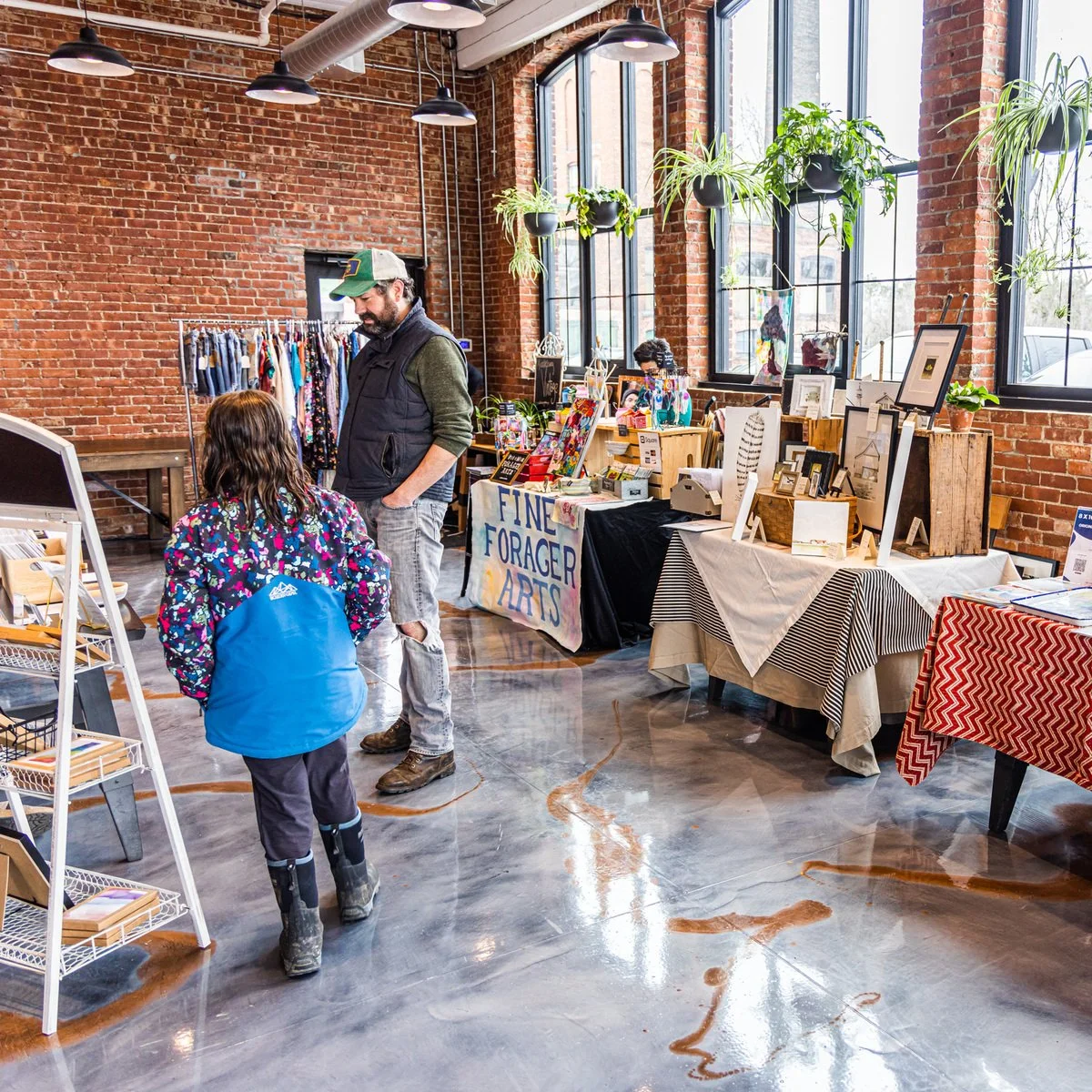 Vendor tables and shoppers beside the windows at a past Burlington Beer Co. market