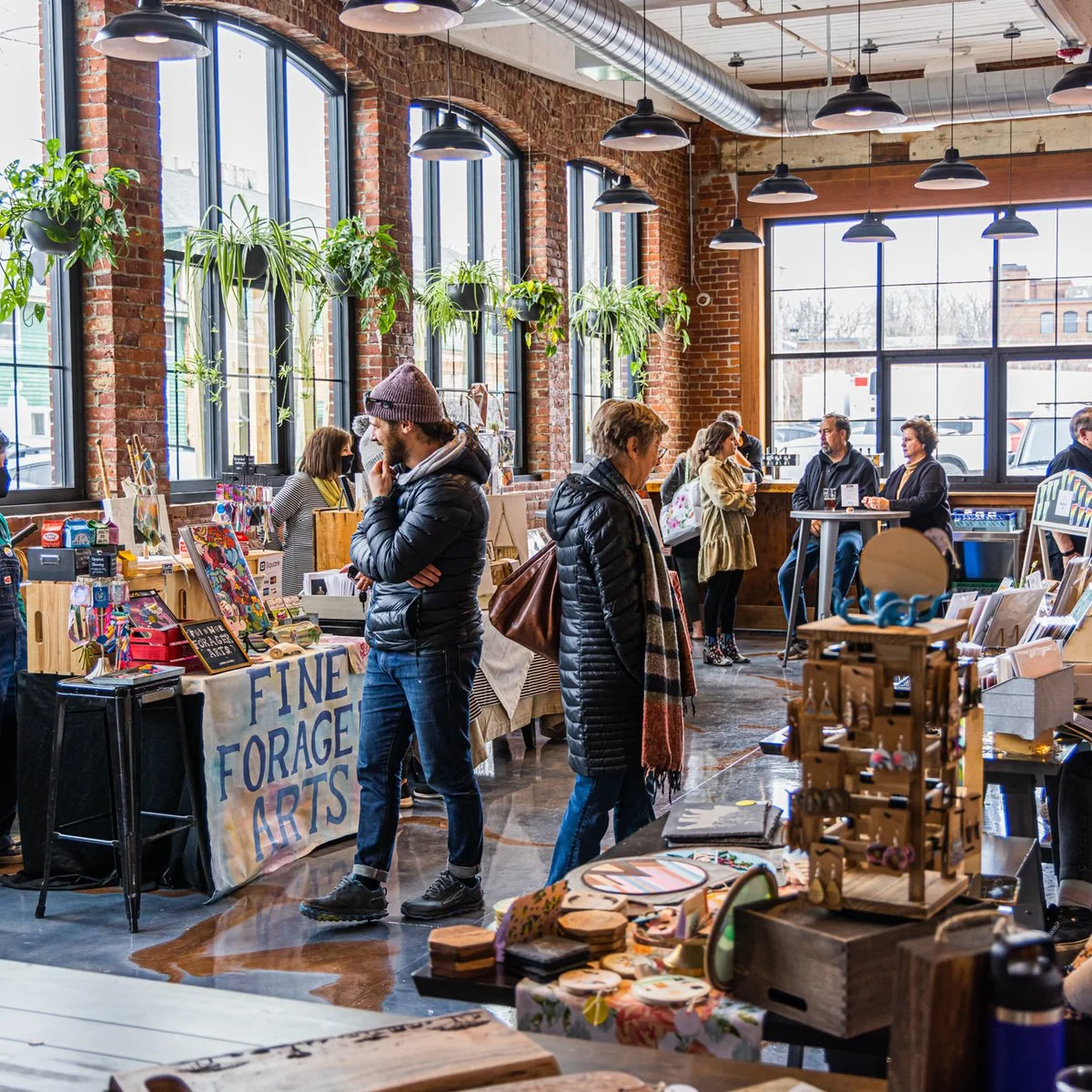 Shoppers browsing vendor stalls at a past indoor market at Burlington Beer Co.